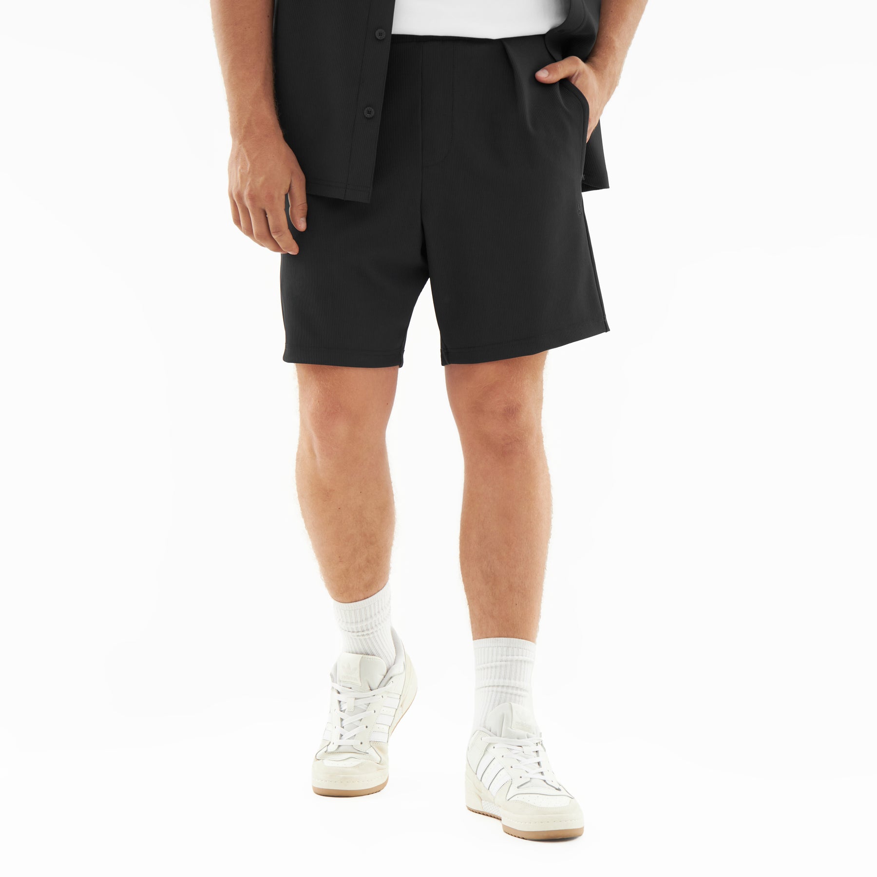 Schwarze kurze Hose aus dem Set 'Mason' für Herren, kombiniert mit weißen Sneakern und Socken