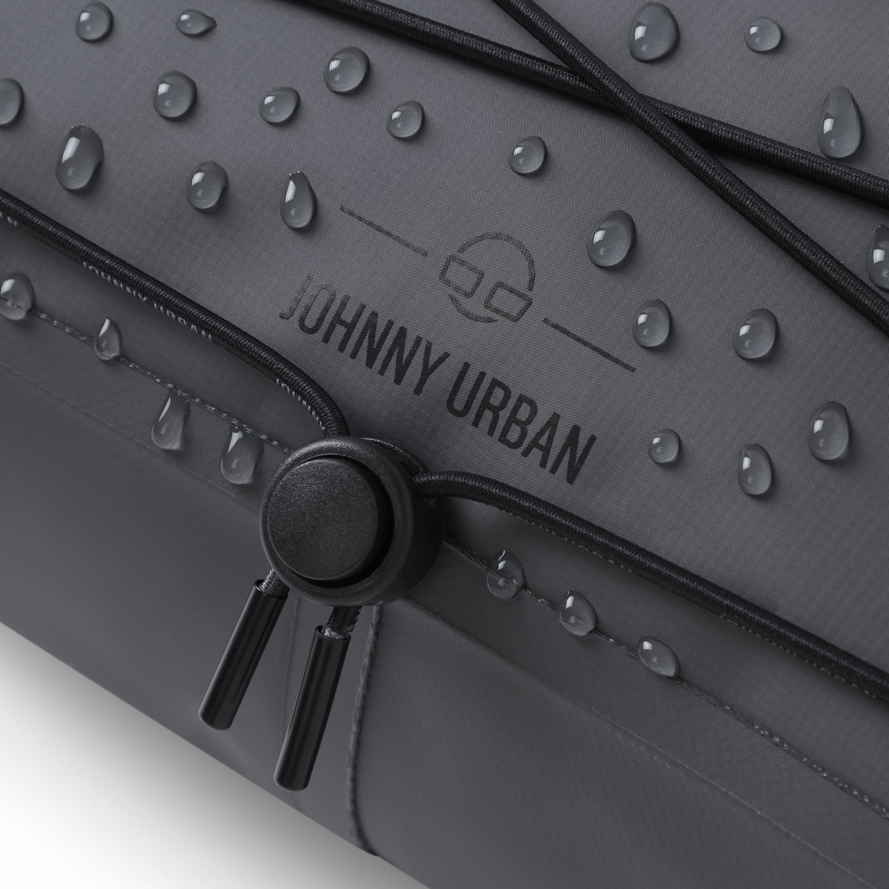 Naheinstellung der schwarzen Lenkertasche 'Arlo' von Johnny Urban mit Wasserperlen auf der Oberfläche