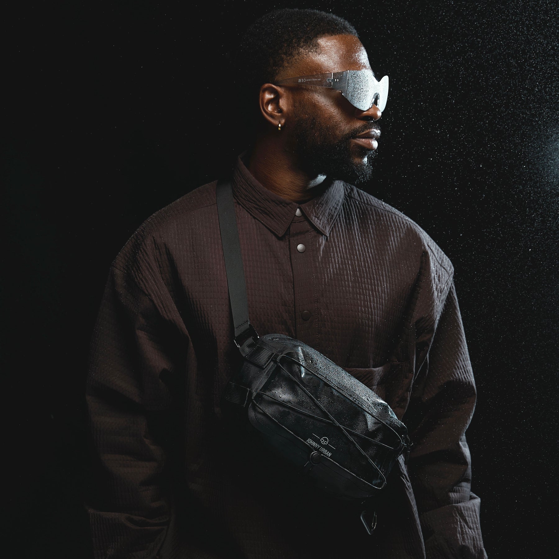 Mann trägt schwarze wasserdichte Lenkertasche Fahrrad 'Arlo' von Johnny Urban als Umhängetasche