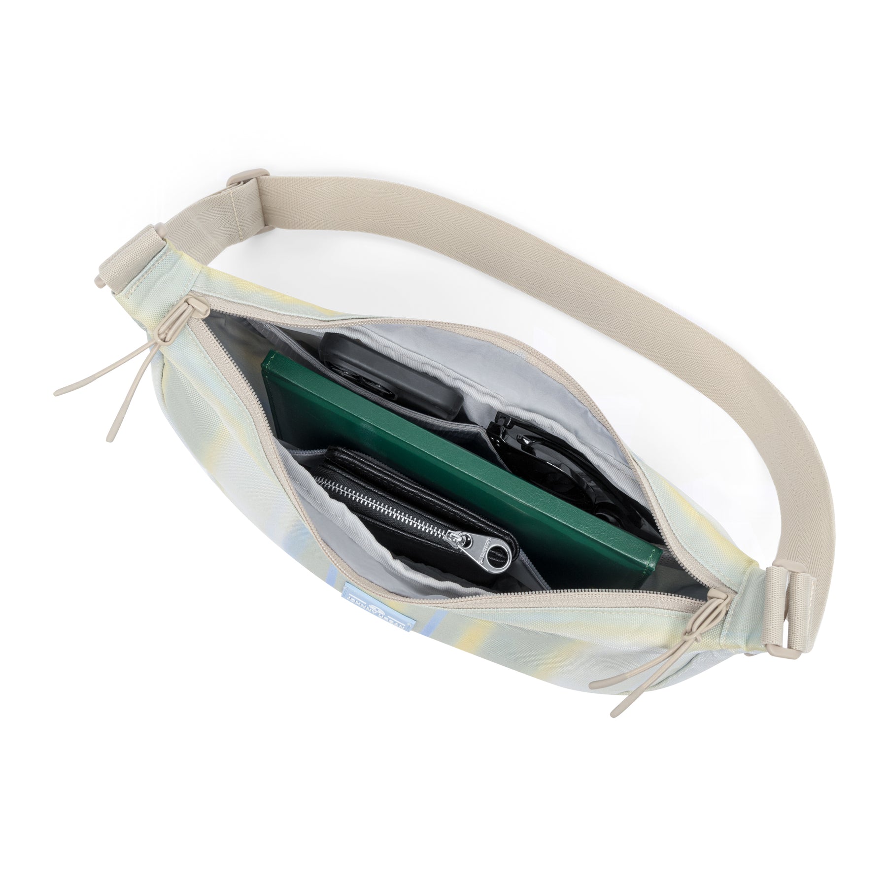 Geöffnete Half Moon Bag 'Ally Medium' mit sichtbaren Fächern, schwarzer Geldbörse, grüner Mappe und schwarzen Sonnenbrillen