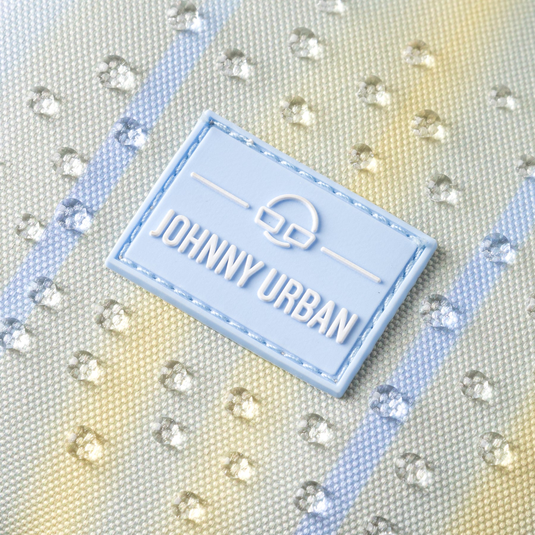 Nahaufnahme des wasserabweisenden Materials der Half Moon Bag "Ally Medium" mit Johnny Urban Markenetikett