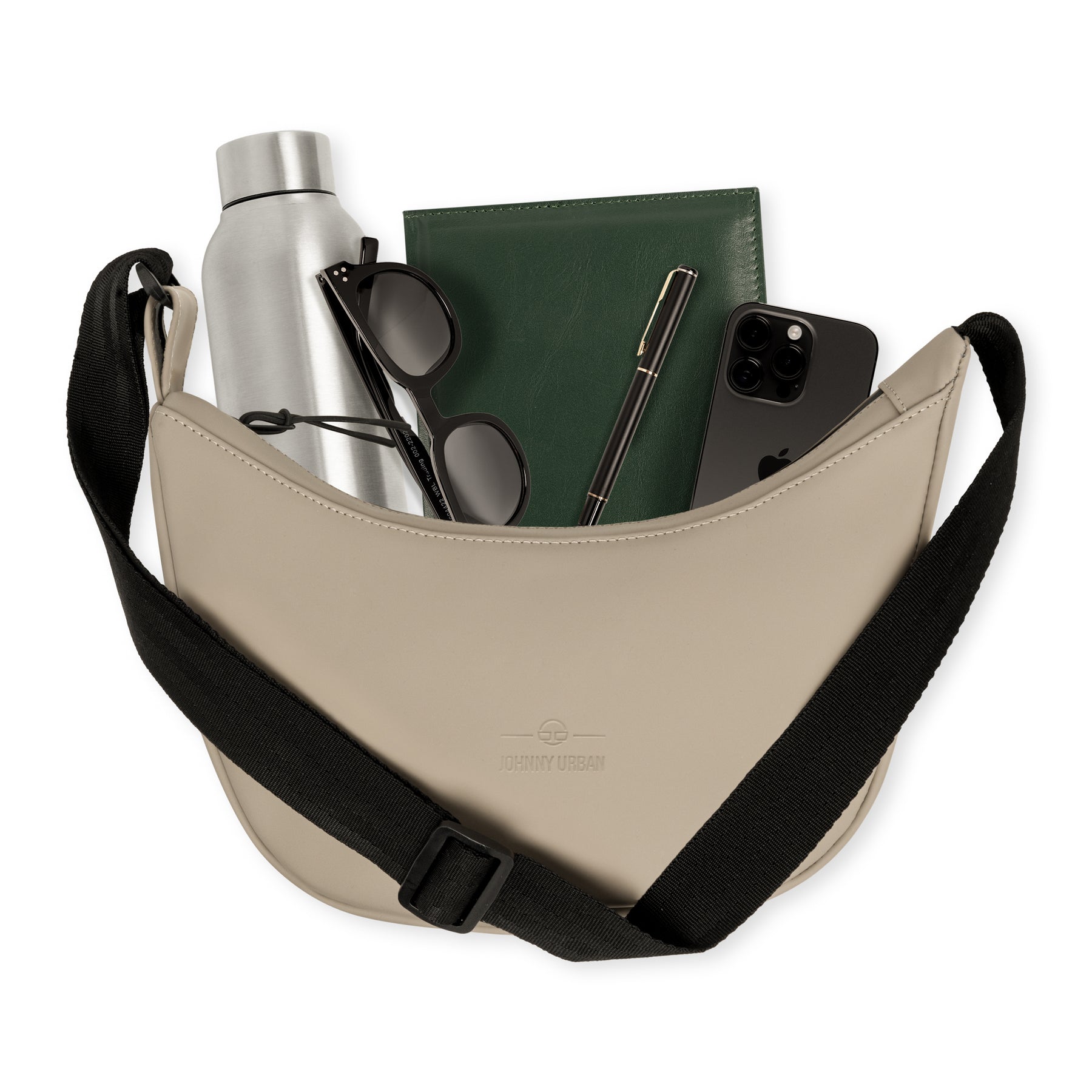 Half Moon Bag ‚Rory‘ von Johnny Urban in Beige mit schwarzem Gurt, gefüllt mit Wasserflasche, schwarzer Sonnenbrille, grünem Notizbuch, Stift und Smartphone