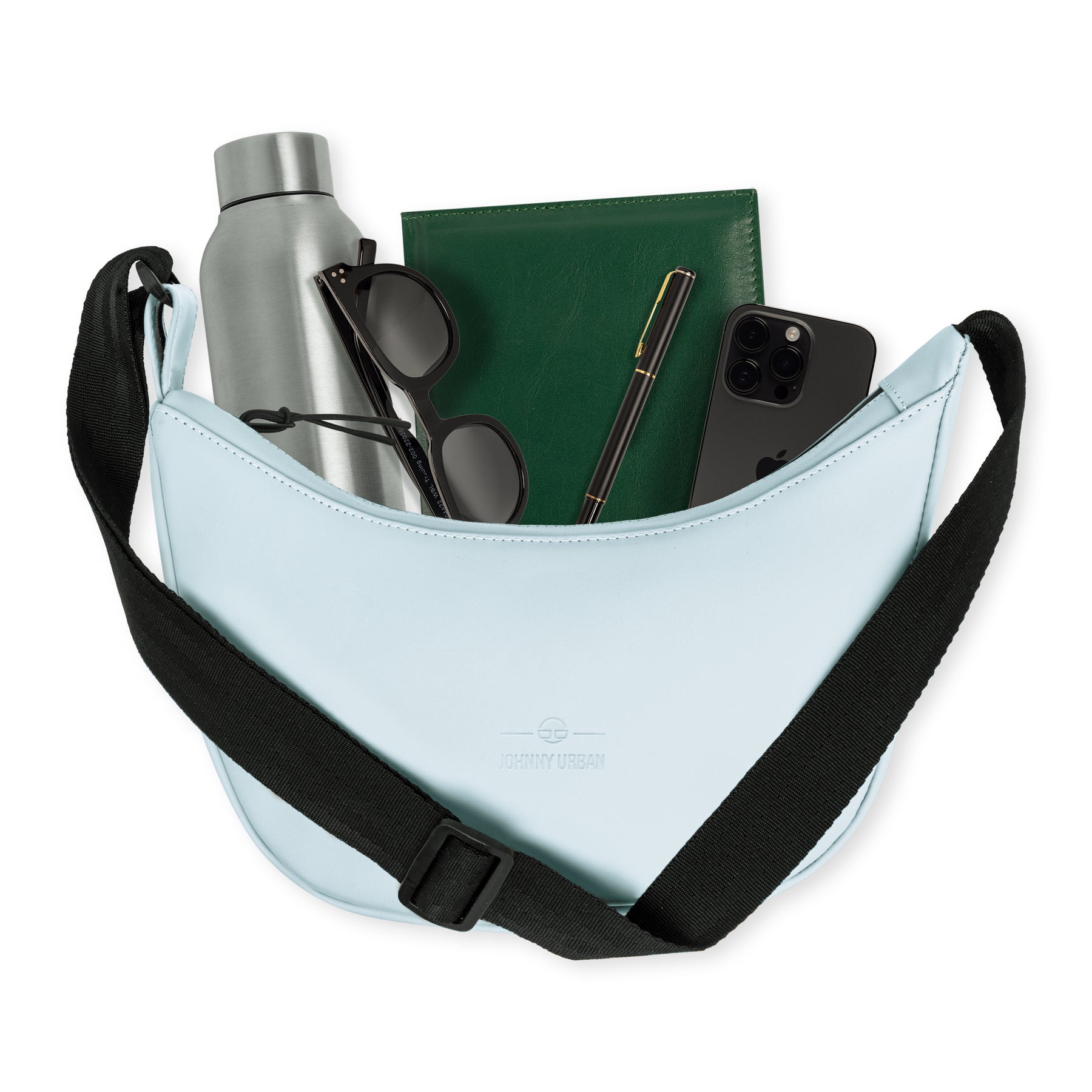Halbmondtasche 'Rory' von Johnny Urban in Hellblau mit schwarzem verstellbarem Tragegurt, gefüllt mit silberner Trinkflasche, schwarzer Sonnenbrille, grünem Notizbuch, schwarzem Stift und schwarzem Smartphone