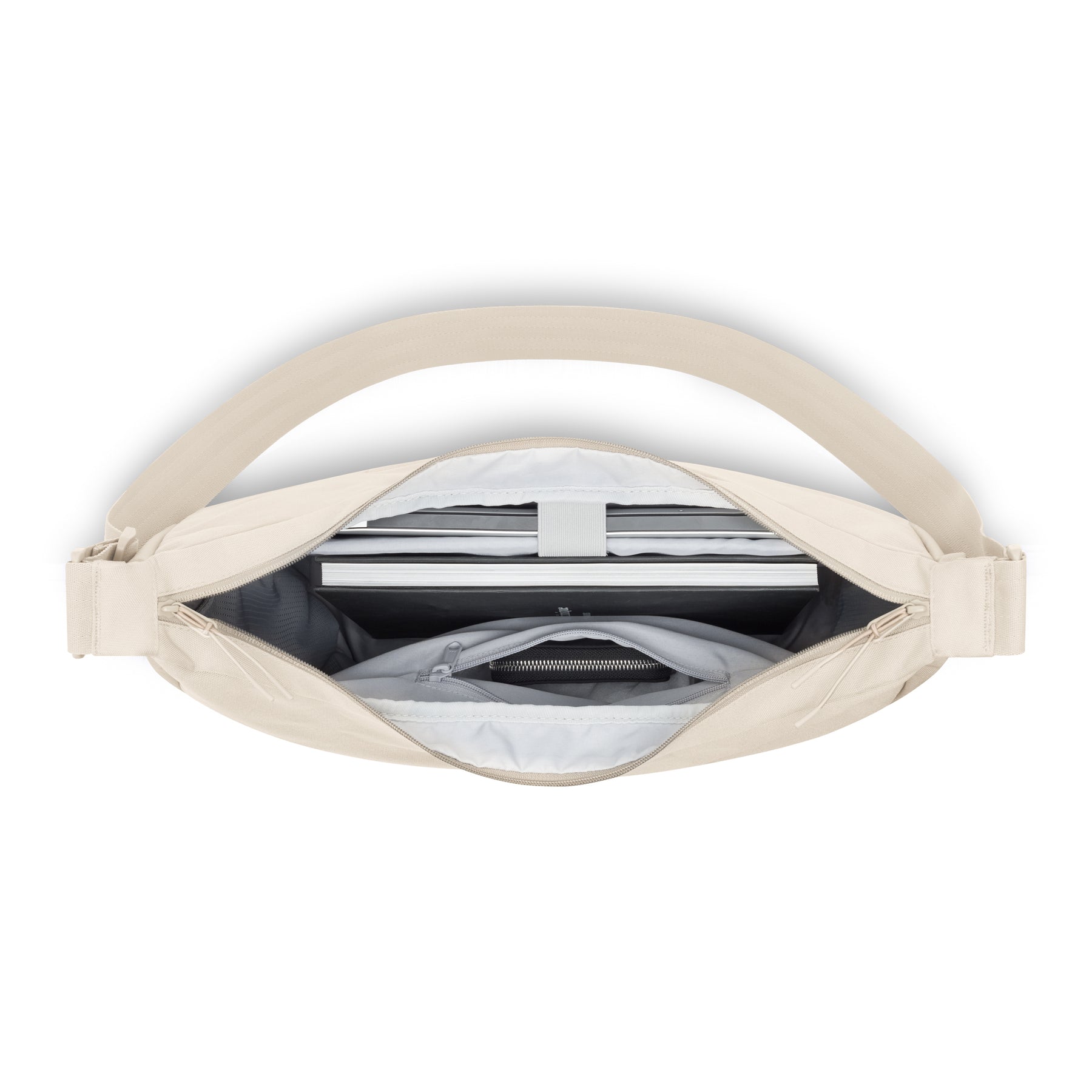 Geöffnete Half Moon Bag 'Ally XL' zeigt Laptopfach und Reißverschlusstasche in beigem Material