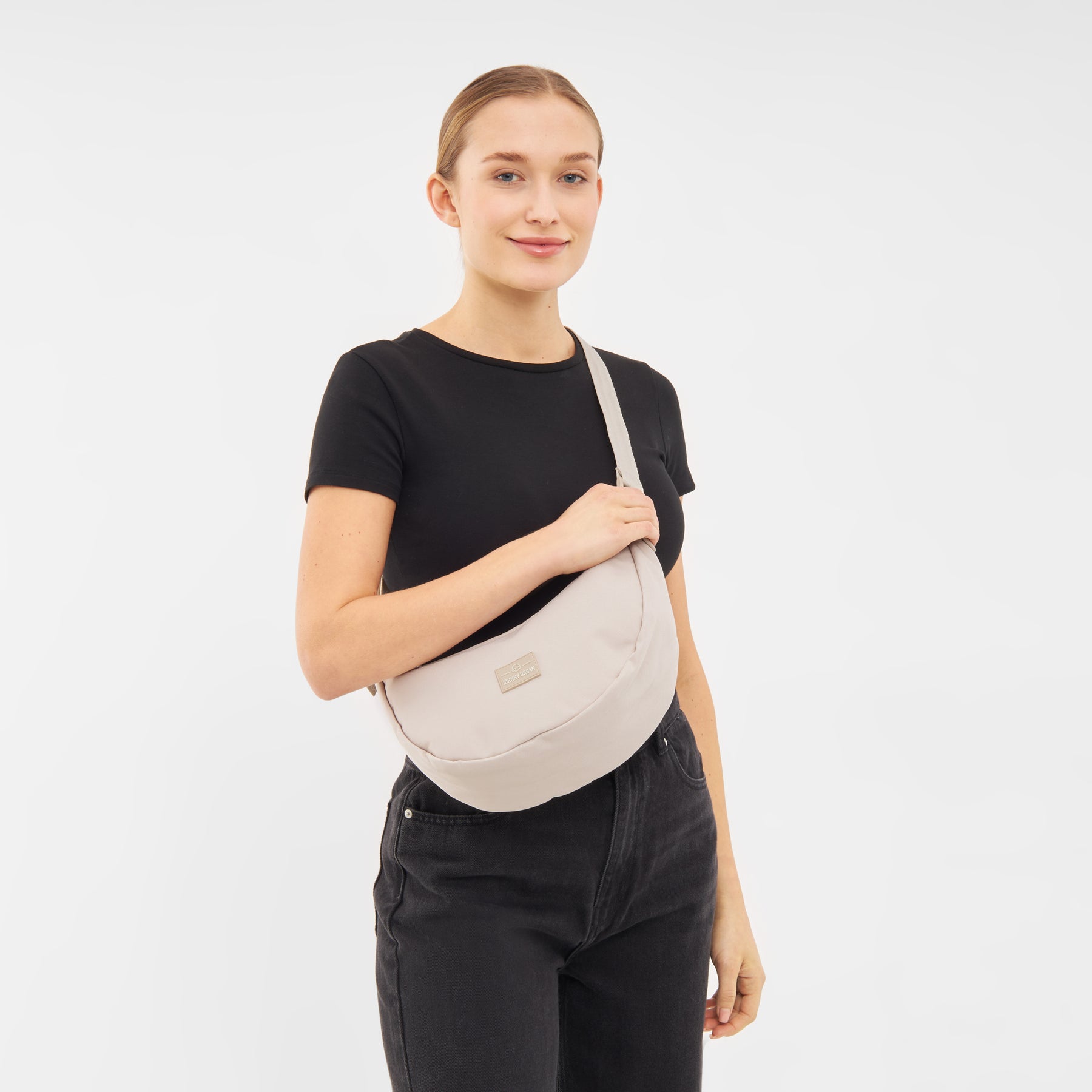 Frau trägt die beige Half Moon Bag 'Ally Medium' von Johnny Urban über der Schulter