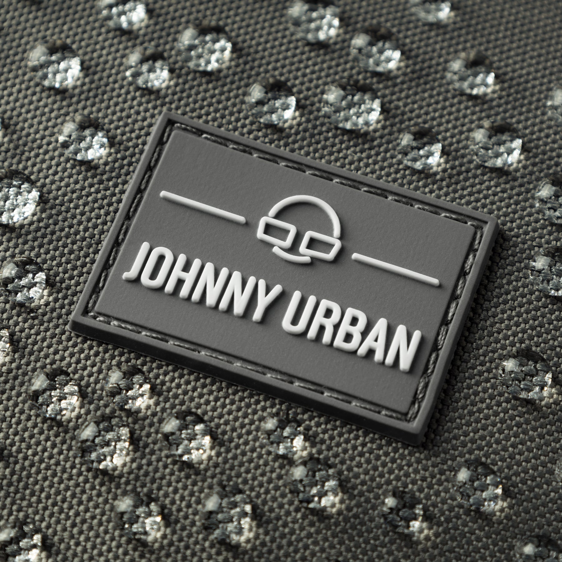Nahaufnahme des wasserabweisenden Materials und Markenlabels der Half Moon Bag 'Ally Medium' von Johnny Urban