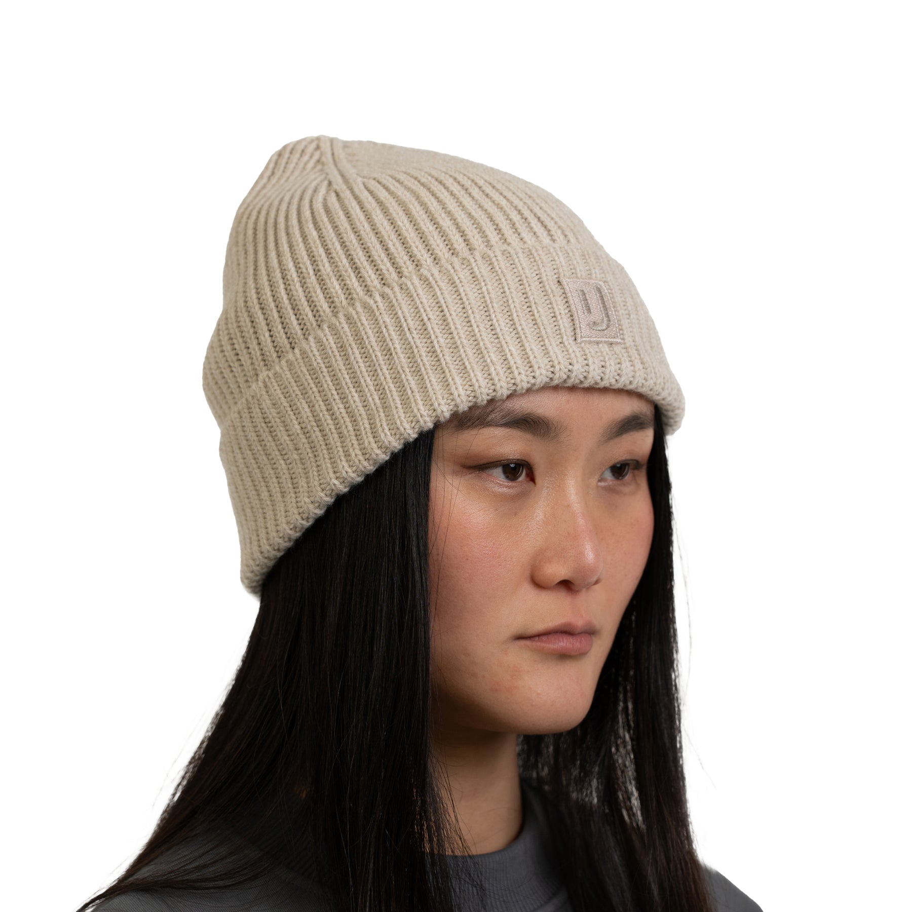 Beige gestrickte Mütze 'Billie' von Johnny Urban an Frau mit langen schwarzen Haaren