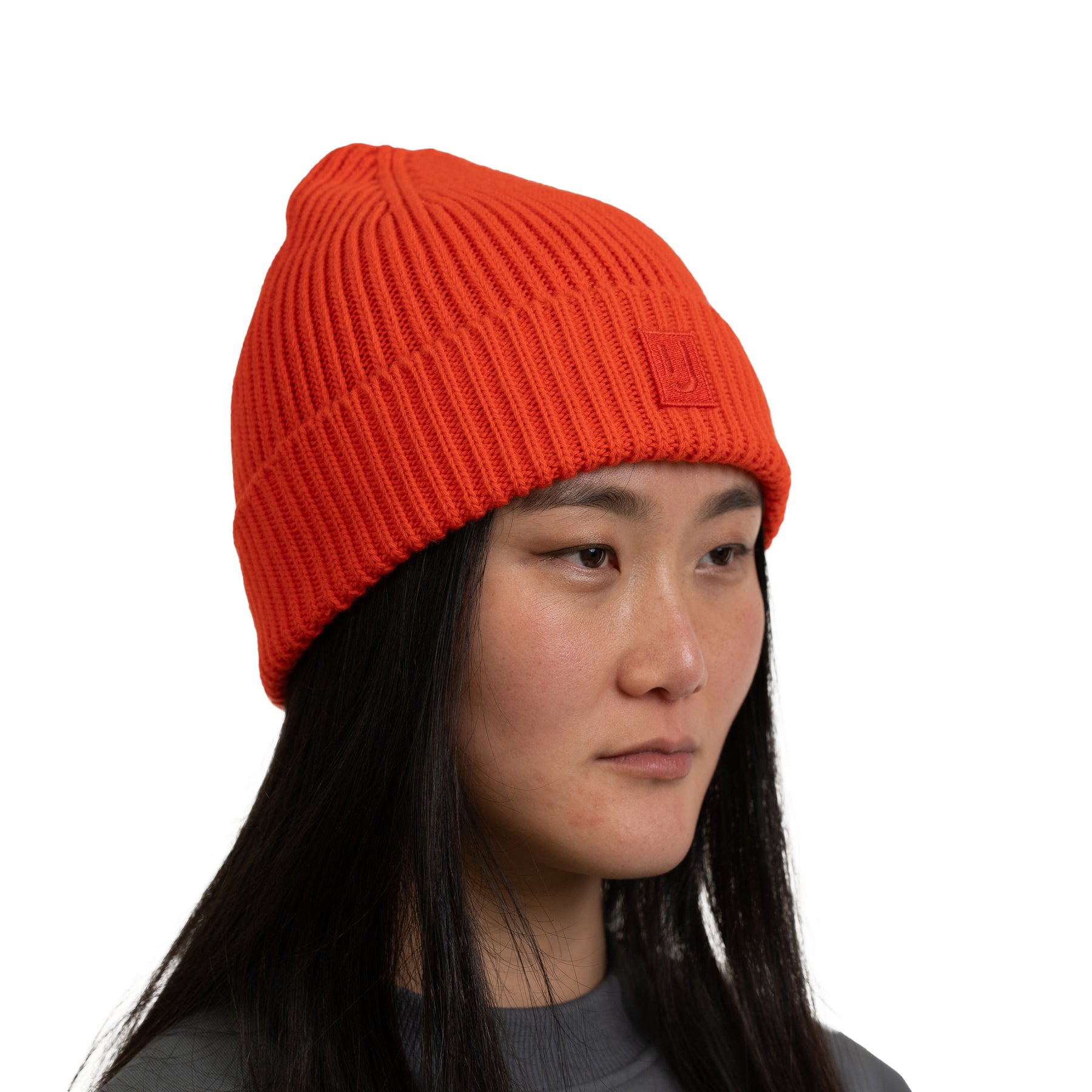 Dame trägt orange-rote, gerippte Strickmütze 'Billie' von Johnny Urban