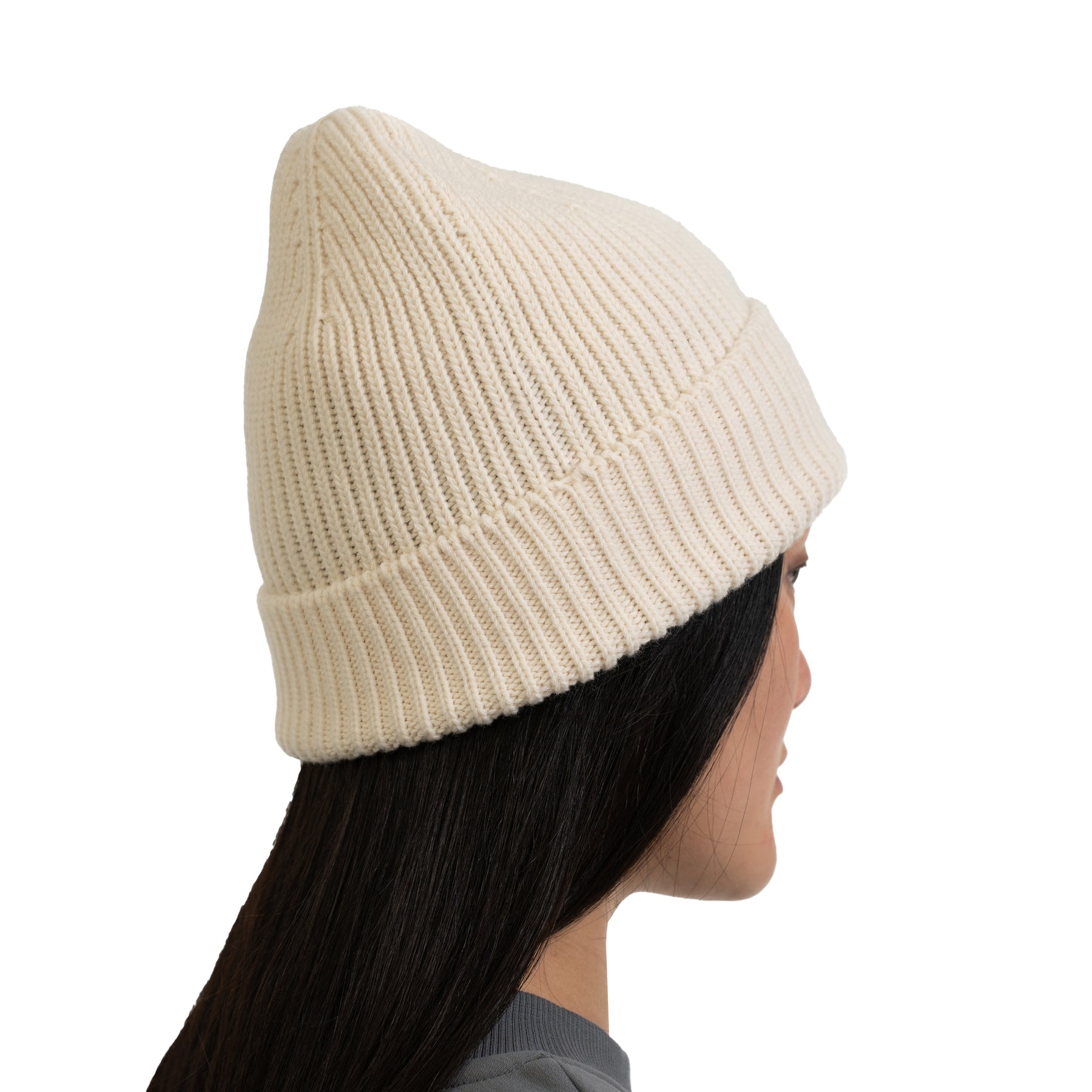 Cremefarbige, gerippte Strickmütze 'Billie' auf dem Kopf einer Frau mit langen schwarzen Haaren