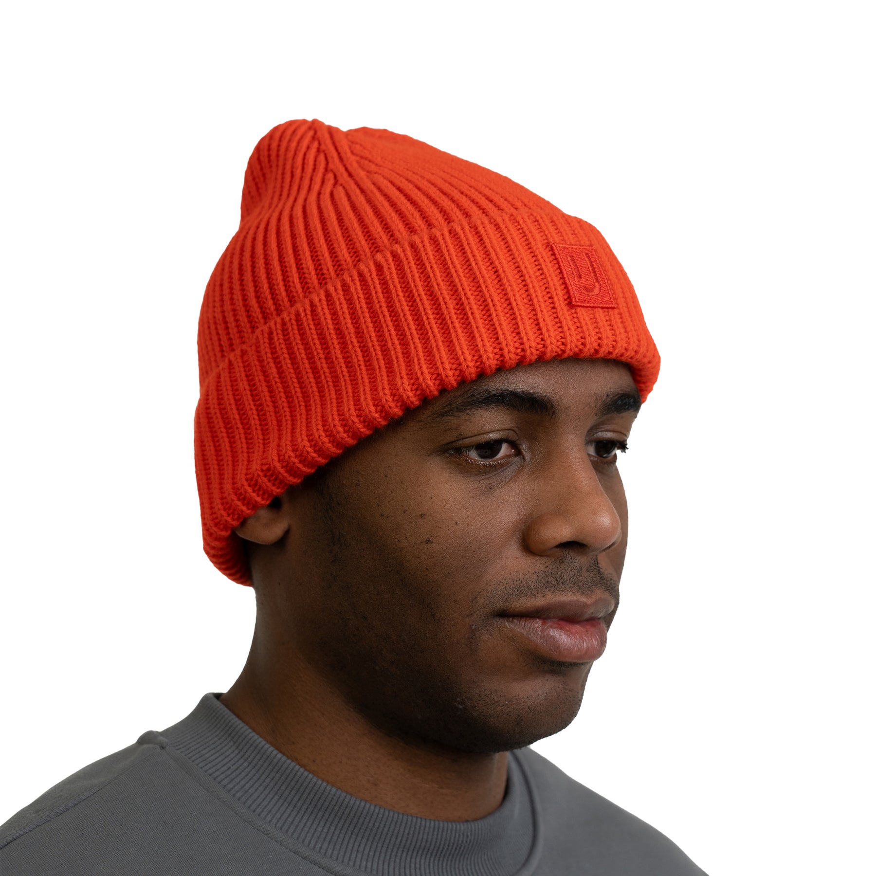 Mann trägt korallrote, gerippte Mütze 'Billie' von Johnny Urban