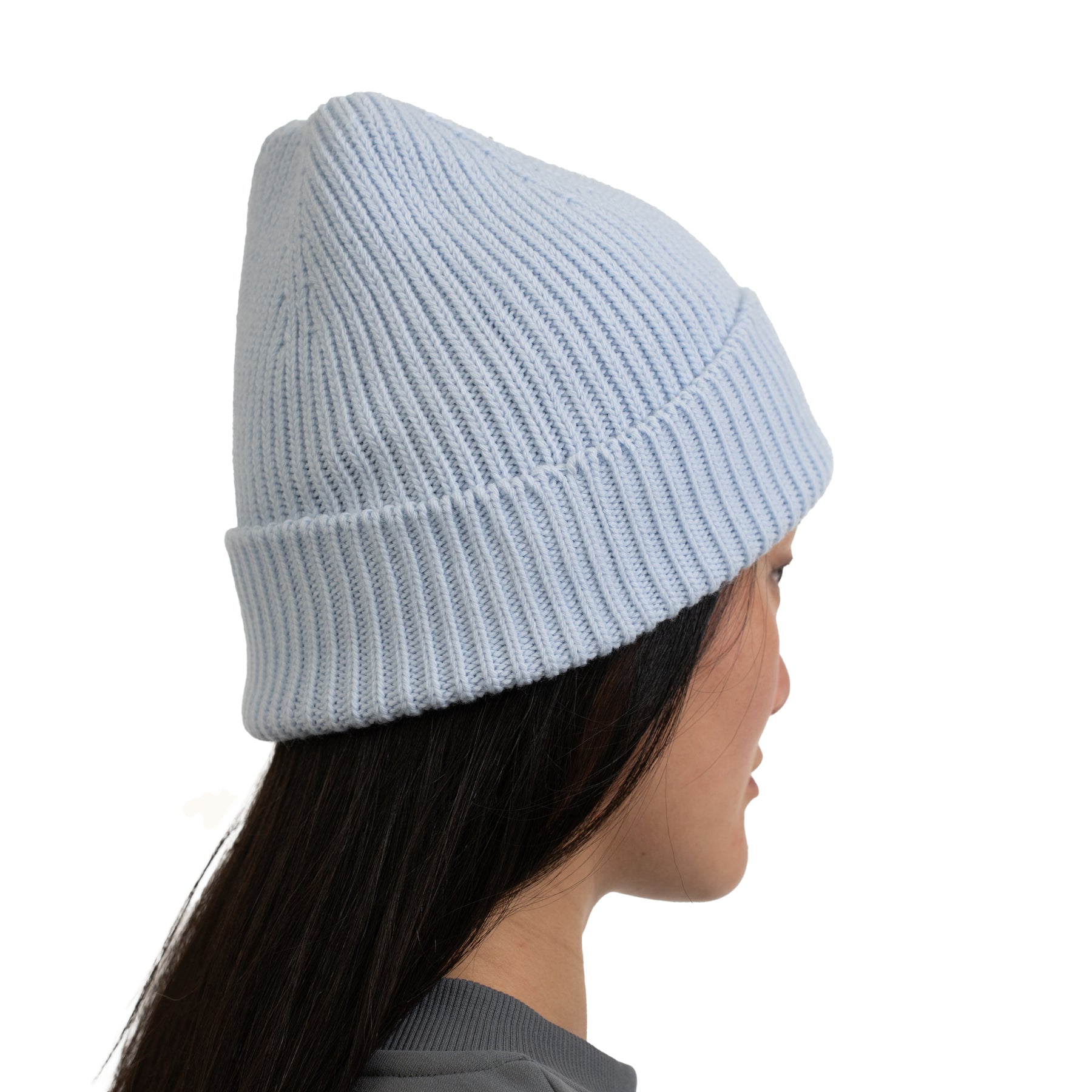 Hellblaue, gerippte Strickmütze 'Billie' an einer Frau von der Seite