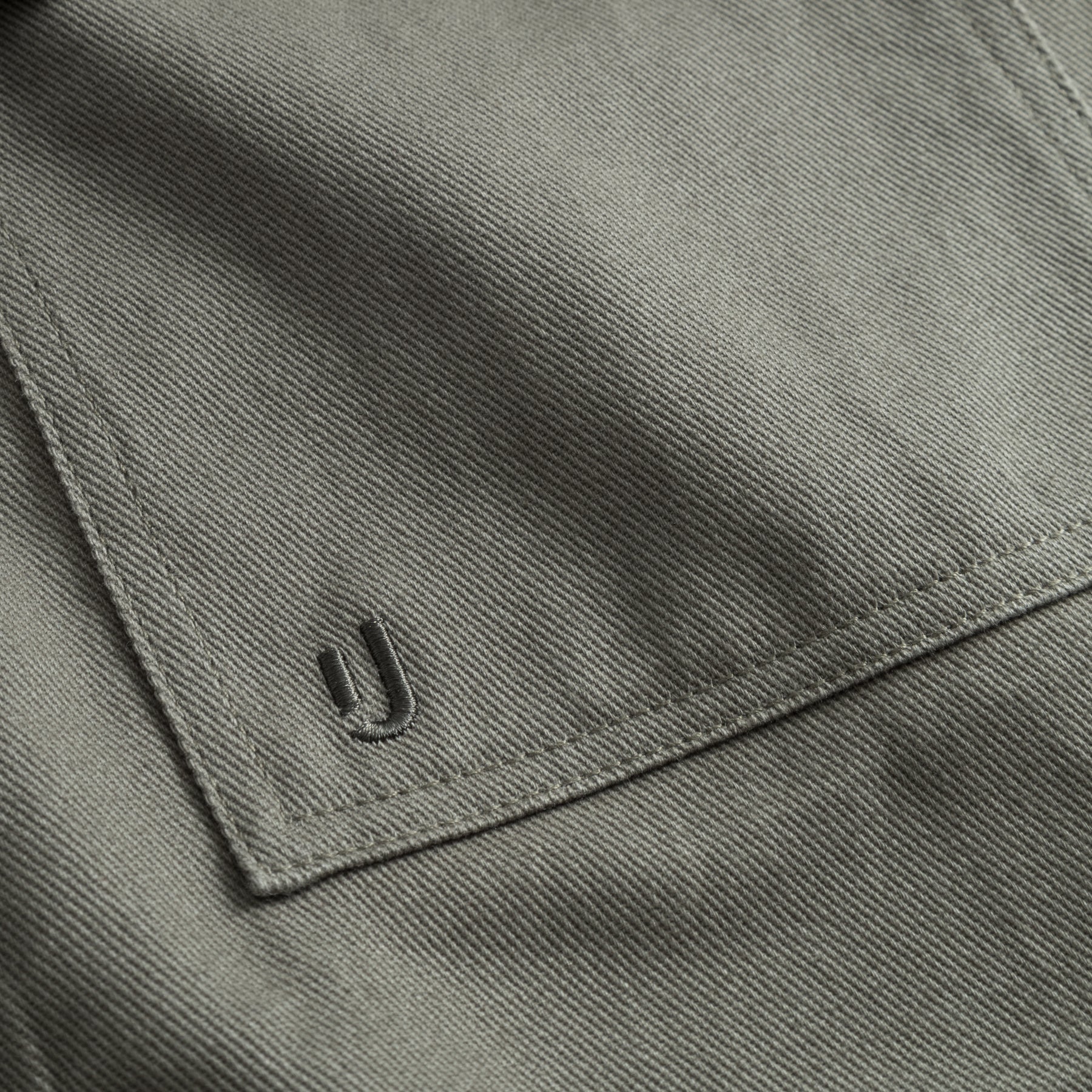 Detailaufnahme der grüngrauen Baumwoll-Overshirttasche 'Cameron' mit gesticktem Markenlogo