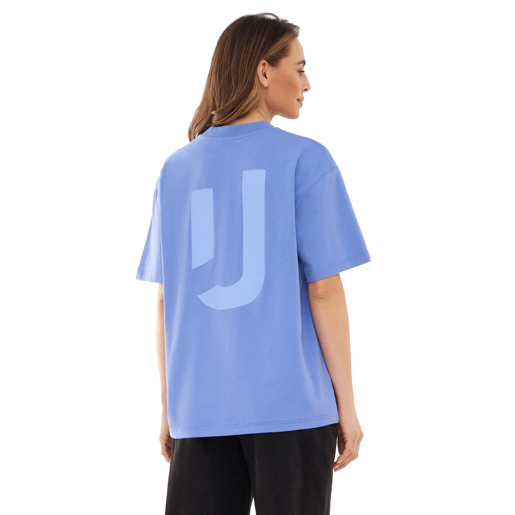 Frau trägt lila-lilafarbenes Oversize-T-Shirt 'Sammy JU' mit großem 'JU' Print auf dem Rücken