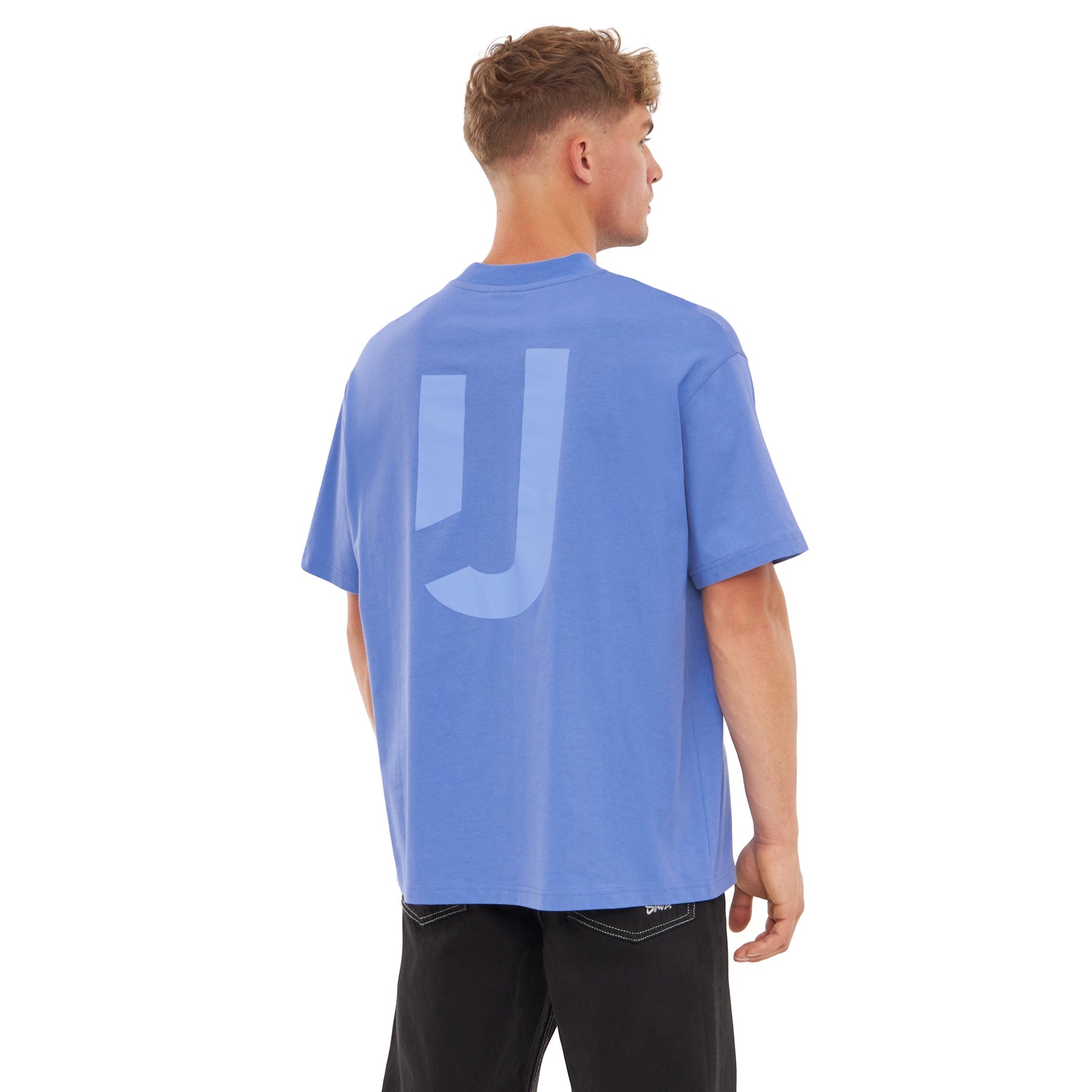 Mann trägt oversized blau-lila T-Shirt 'Sammy JU' mit großem 'JU'-Print auf dem Rücken