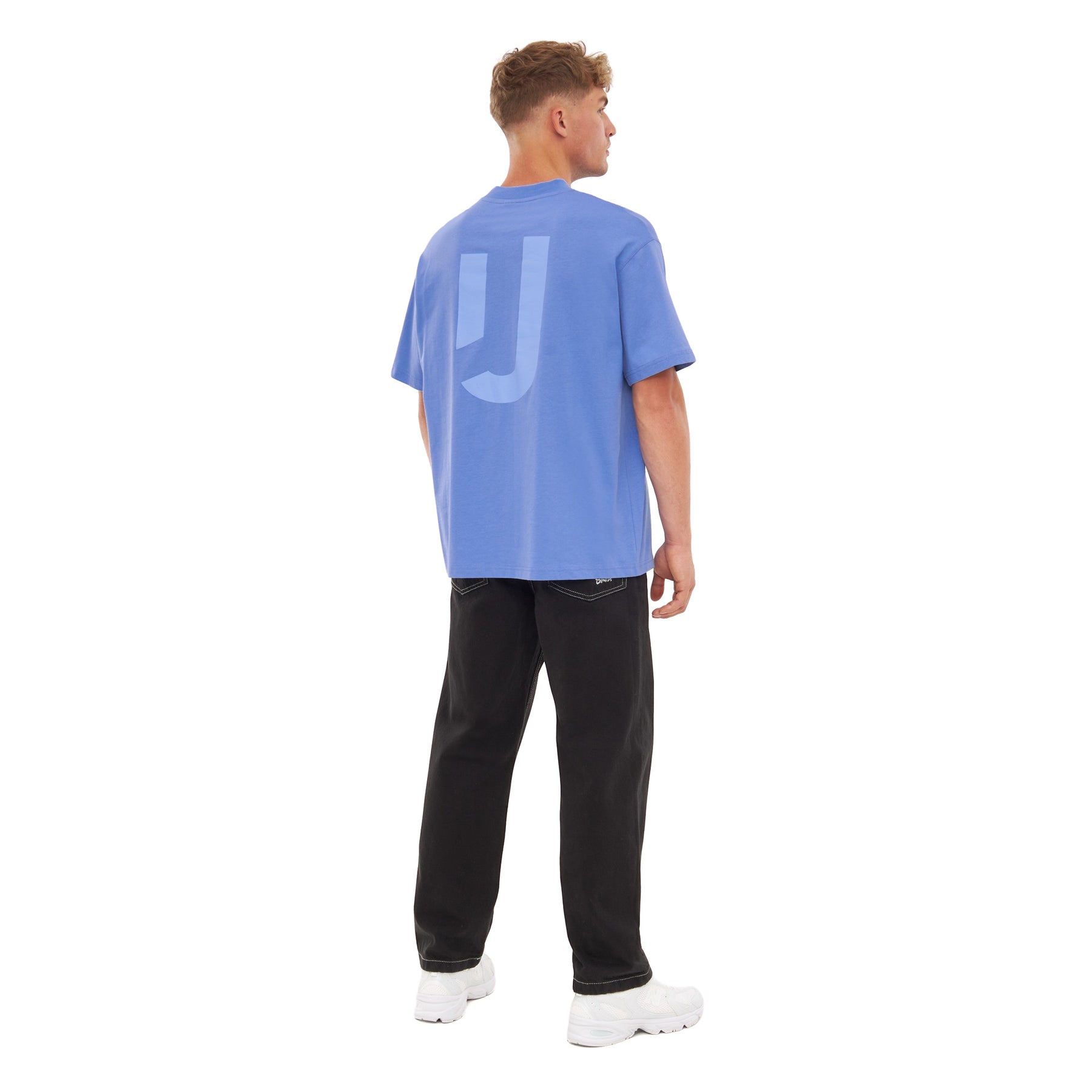 Mann von hinten in oversized blau-lila T-Shirt 'Sammy JU' und schwarzer Hose