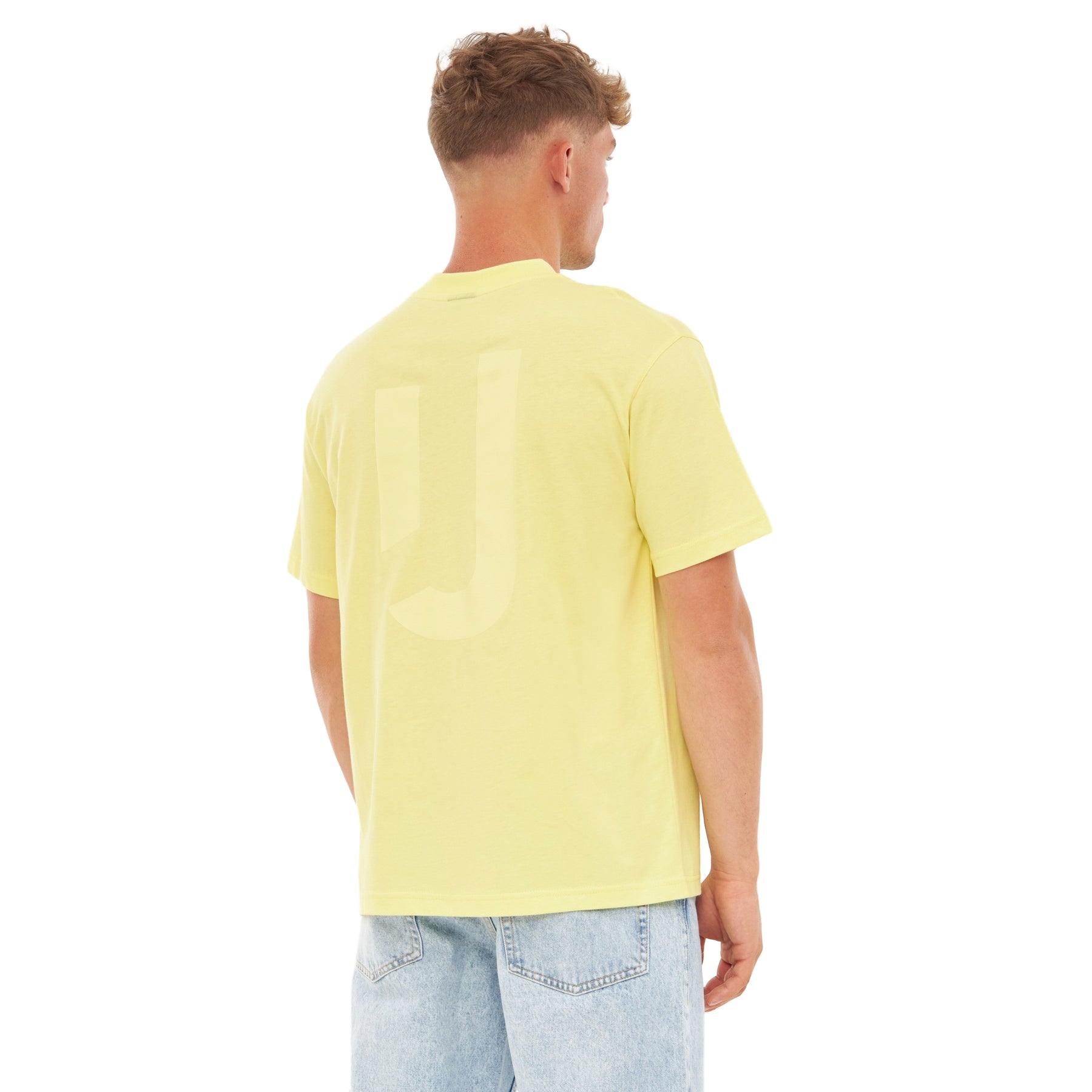 Mann trägt gelbes Oversize-T-Shirt 'Sammy JU' mit dezentem 'JU'-Print auf dem Rücken