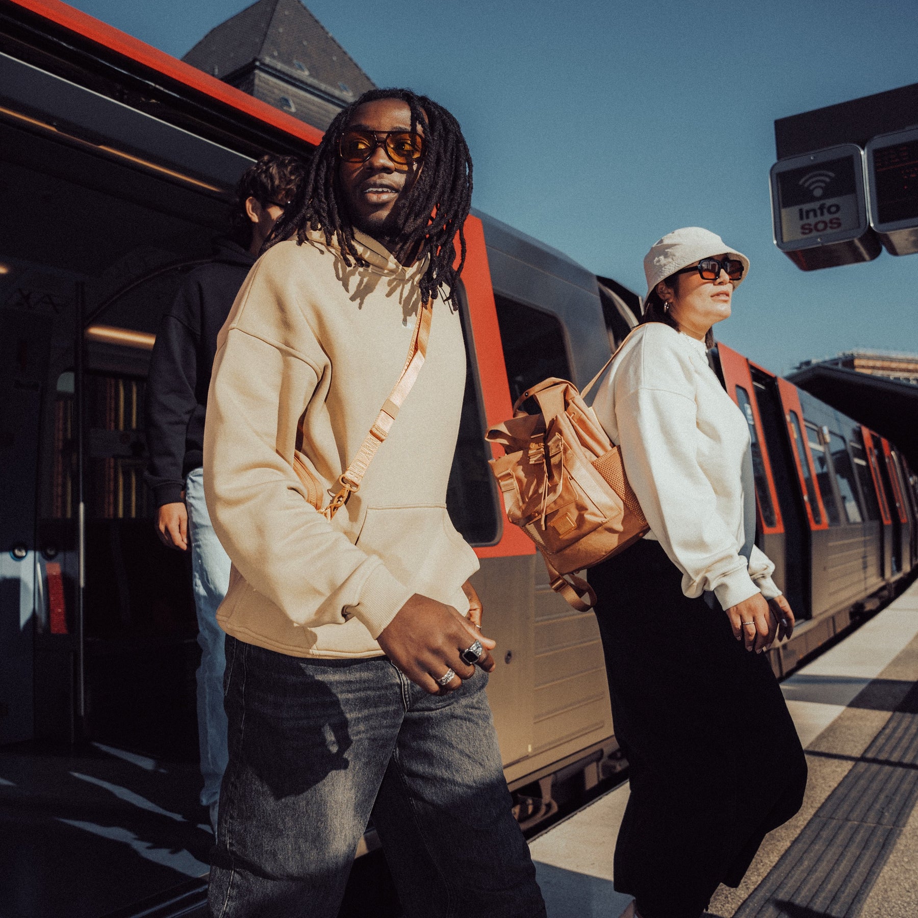 Person trägt beige oversized Hoodie 'Cody' von Johnny Urban mit Rucksack am U-Bahn-Bahnsteig