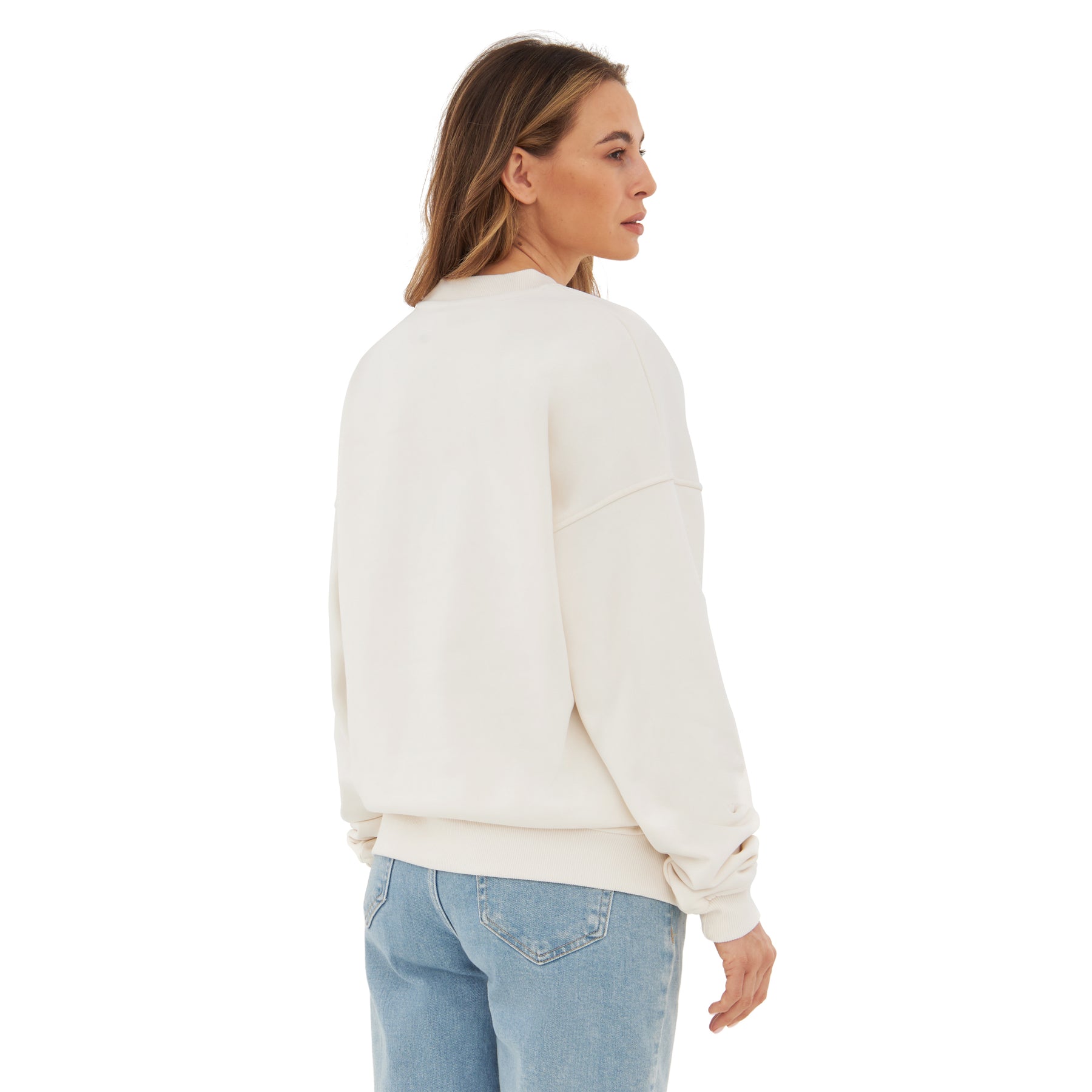 Frau trägt weißen oversized Crewneck-Sweatshirt 'Carter' von hinten mit blauen Jeans