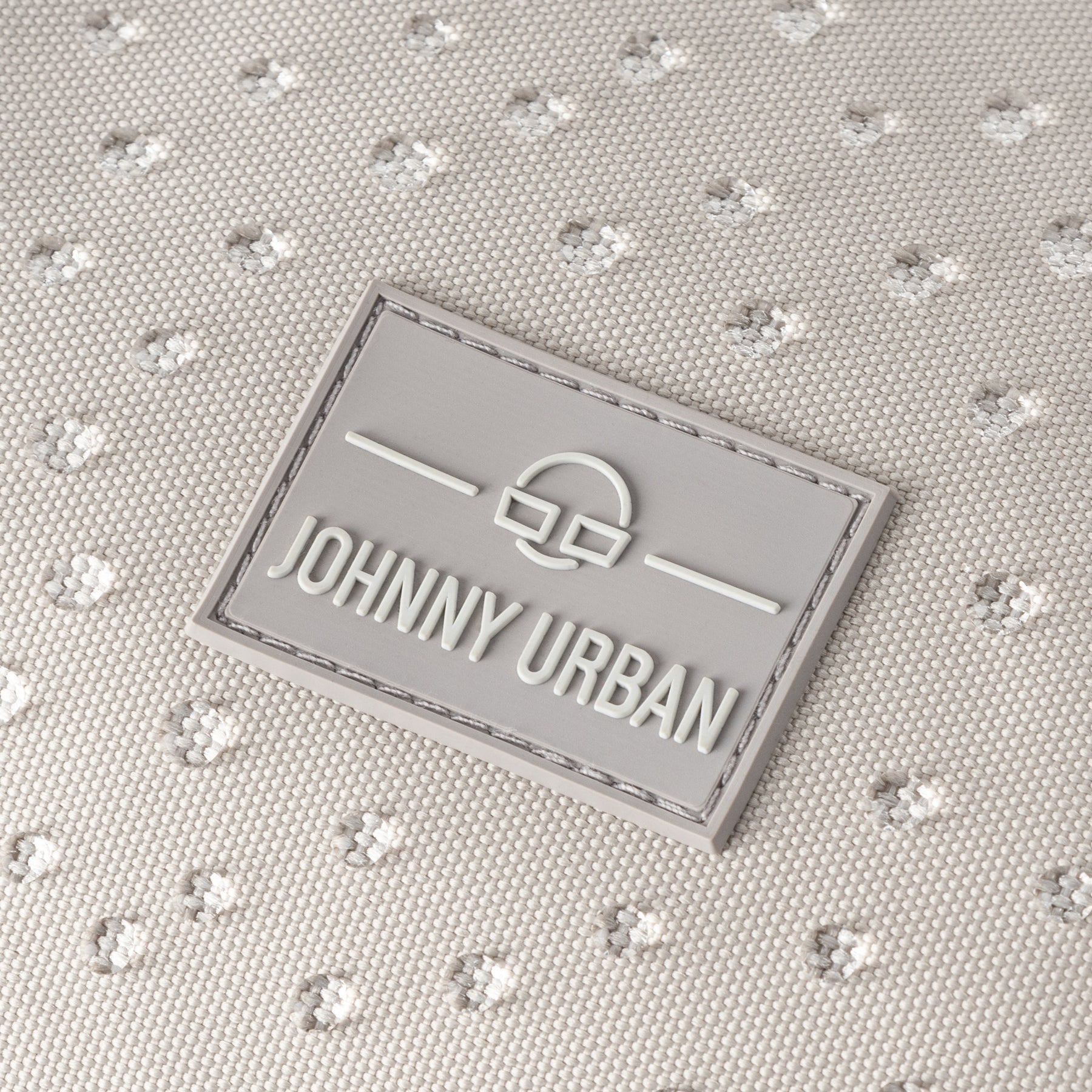 Grau-weißes, wasserabweisendes Material mit feinem Punktemuster und Johnny Urban Logo-Patch