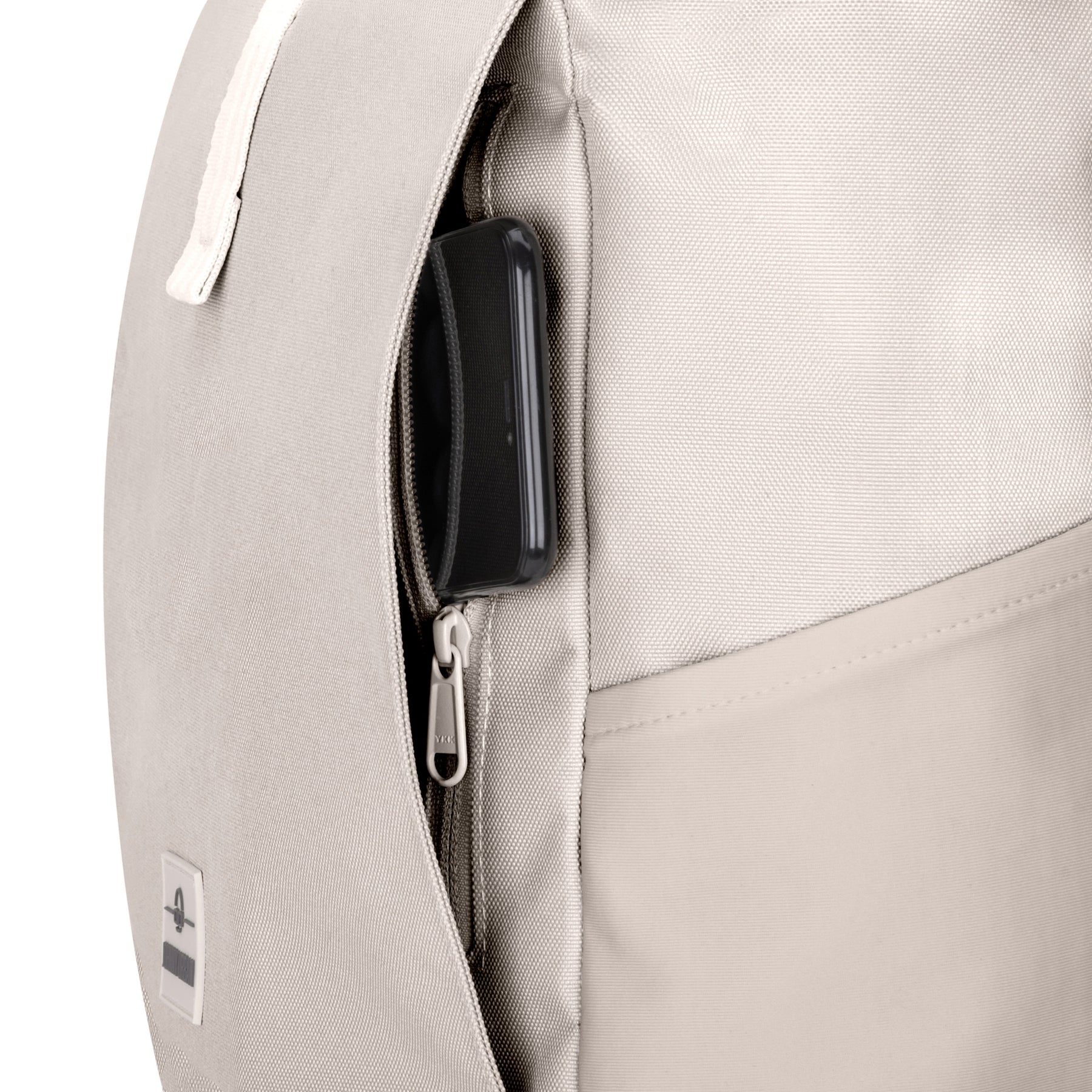 Beiger Rolltop-Rucksack 'Allen Large' mit seitlicher Reißverschlusstasche und herausragendem schwarzen Smartphone