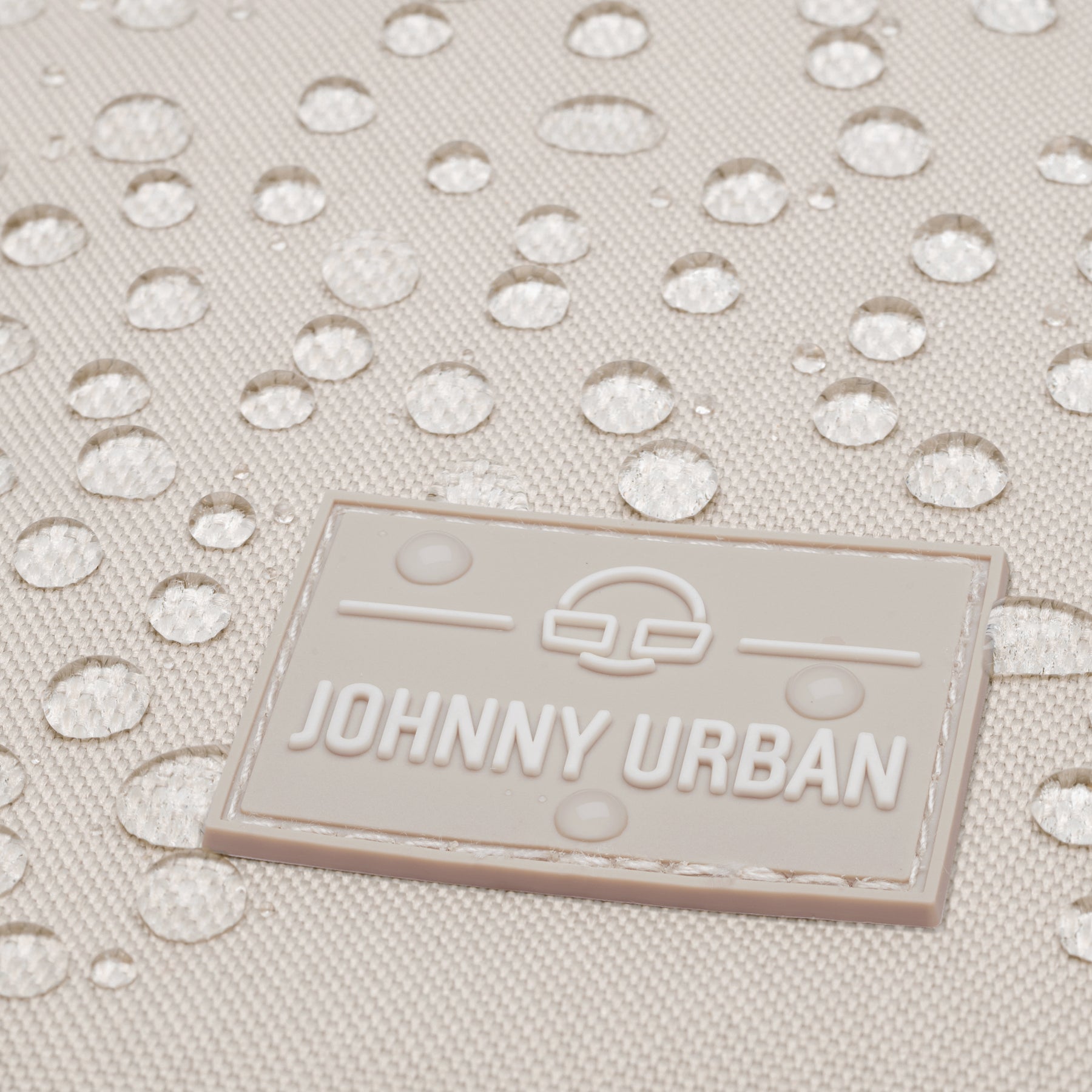 Detail des beigen Rolltop-Rucksacks 'Allen Medium' von Johnny Urban mit wasserabweisendem Stoff und Logo-Patch