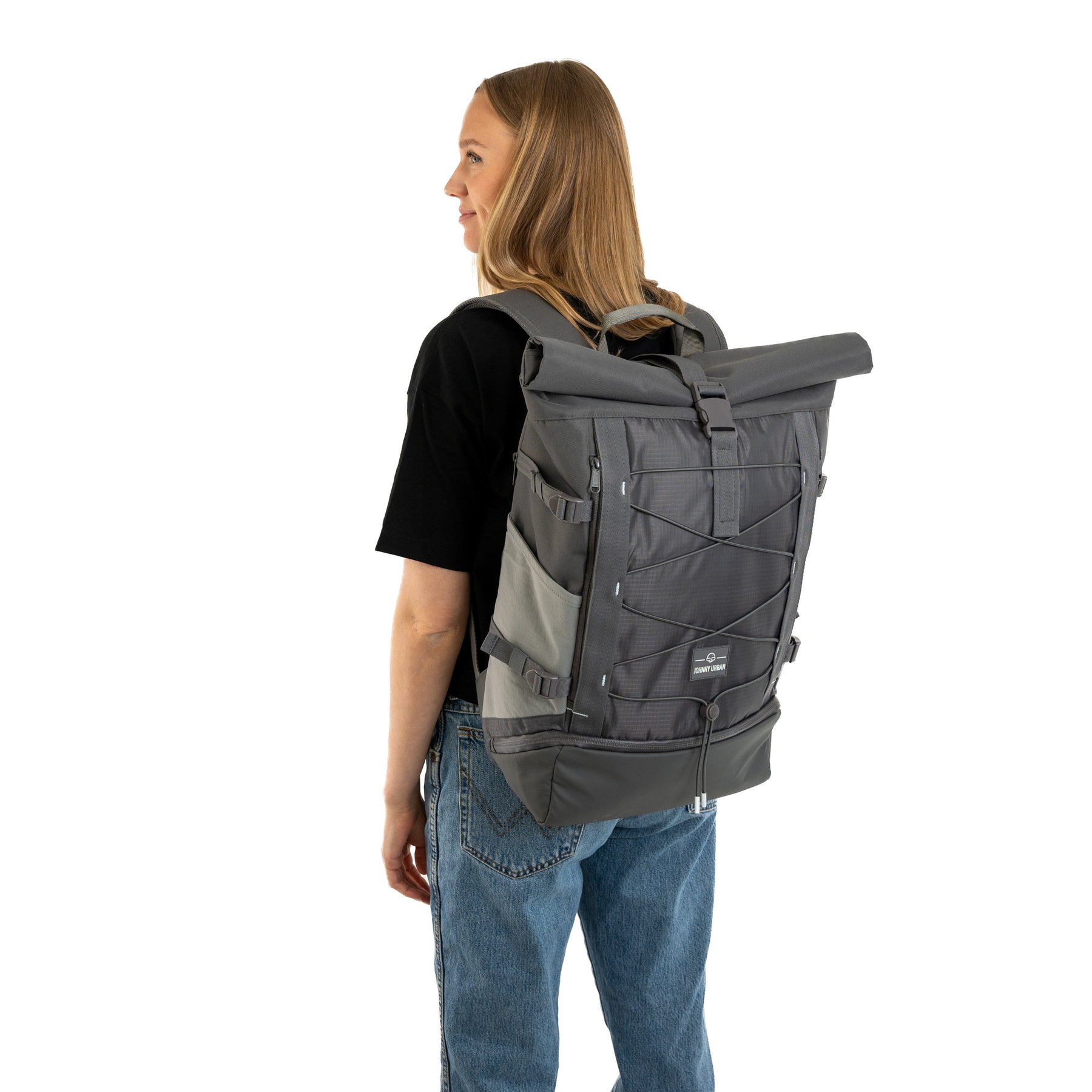 Frau mit schwarzem T-Shirt und Jeans trägt grauen Rolltop Rucksack 'Allen Large Move' von Johnny Urban
