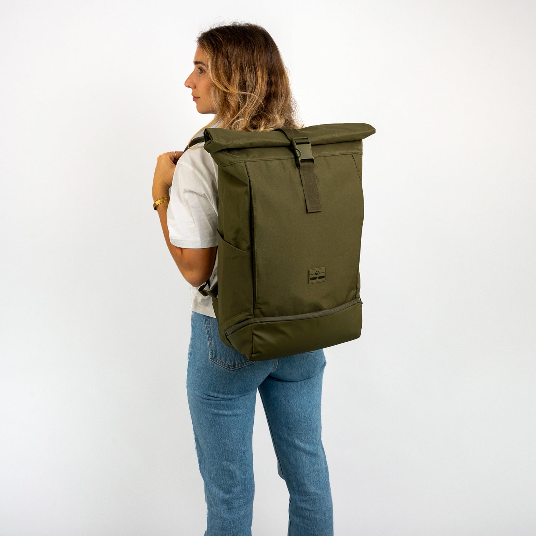 Frau mit olivgrünem Rolltop Rucksack 'Allen XL' von Johnny Urban, trägt weiße T-Shirt und Jeans