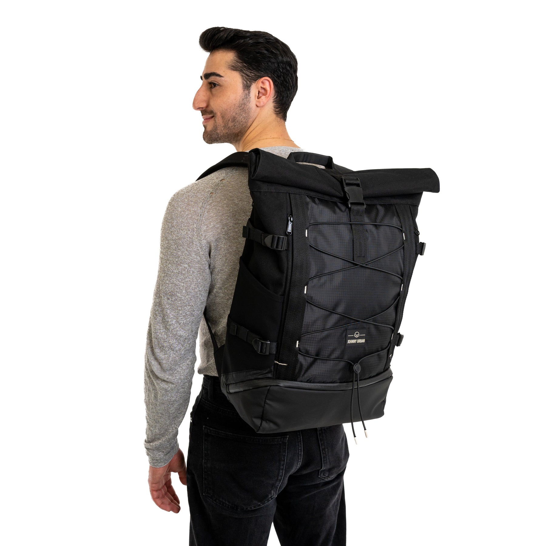 Mann mit grauem Pullover trägt schwarzen Rolltop Rucksack 'Allen Large Move' von Johnny Urban