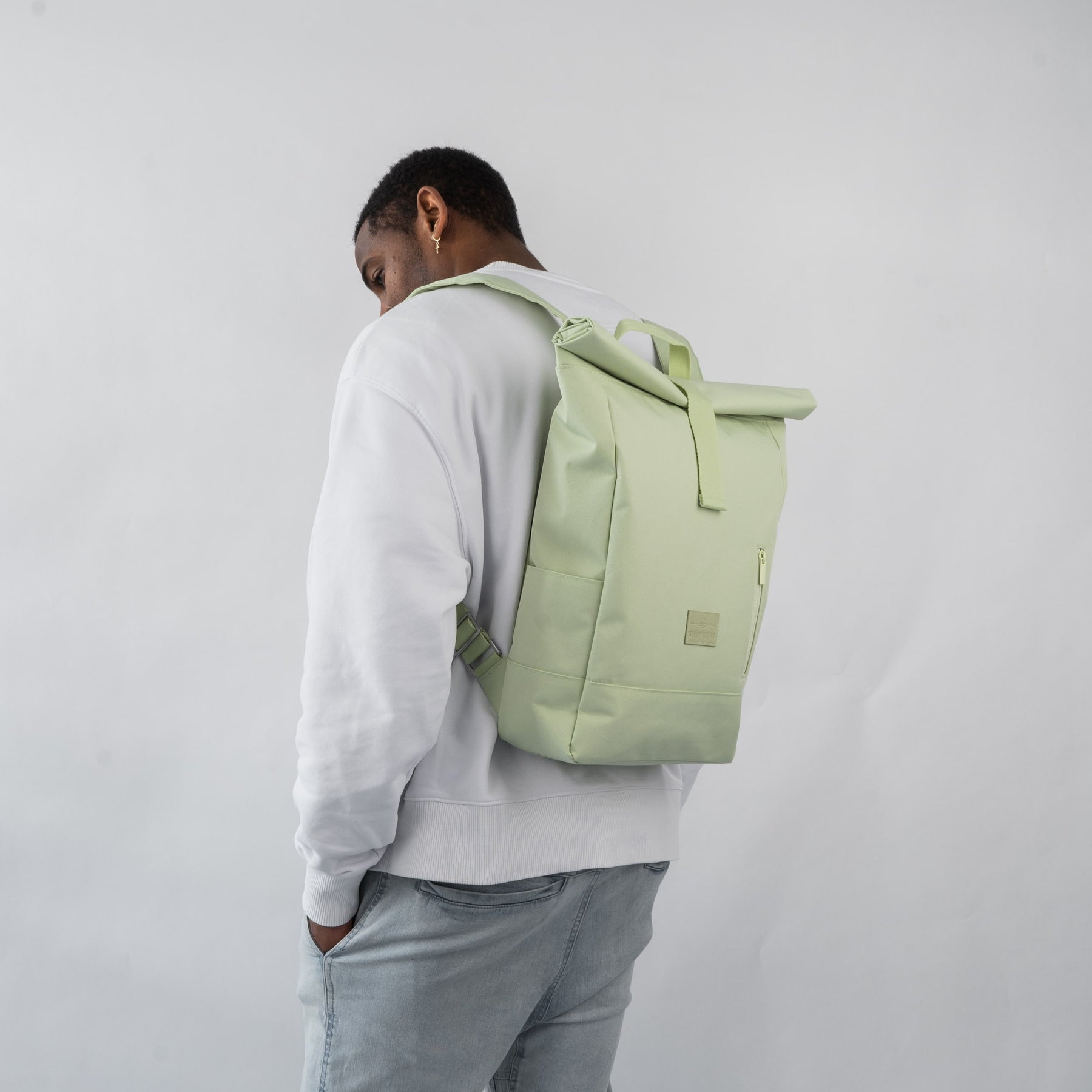 Mann von hinten mit hellem Rolltop-Rucksack 'Robin Medium' in Limettengrün