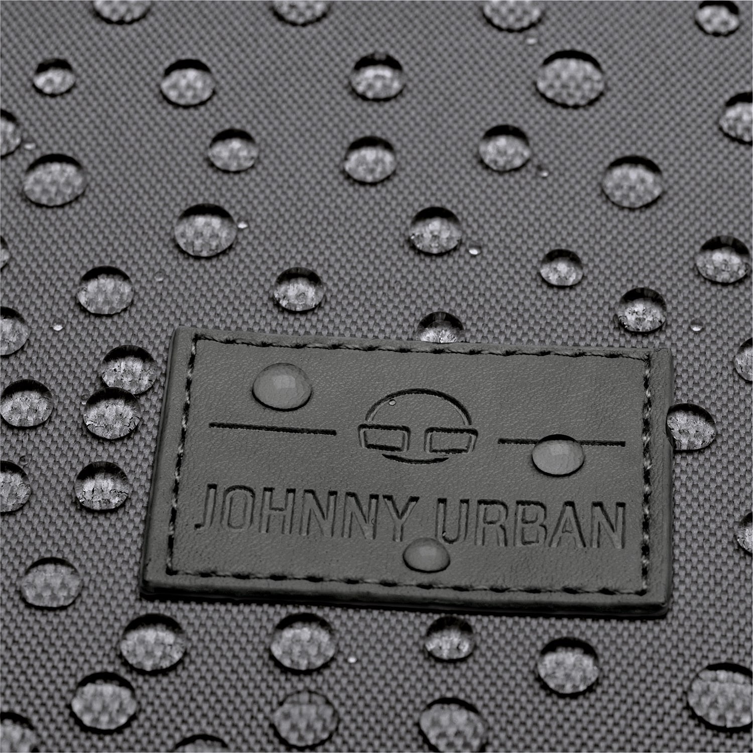 Johnny Urban Logo auf wasserabweisendem dunkelgrauem Stoff mit Wassertropfen