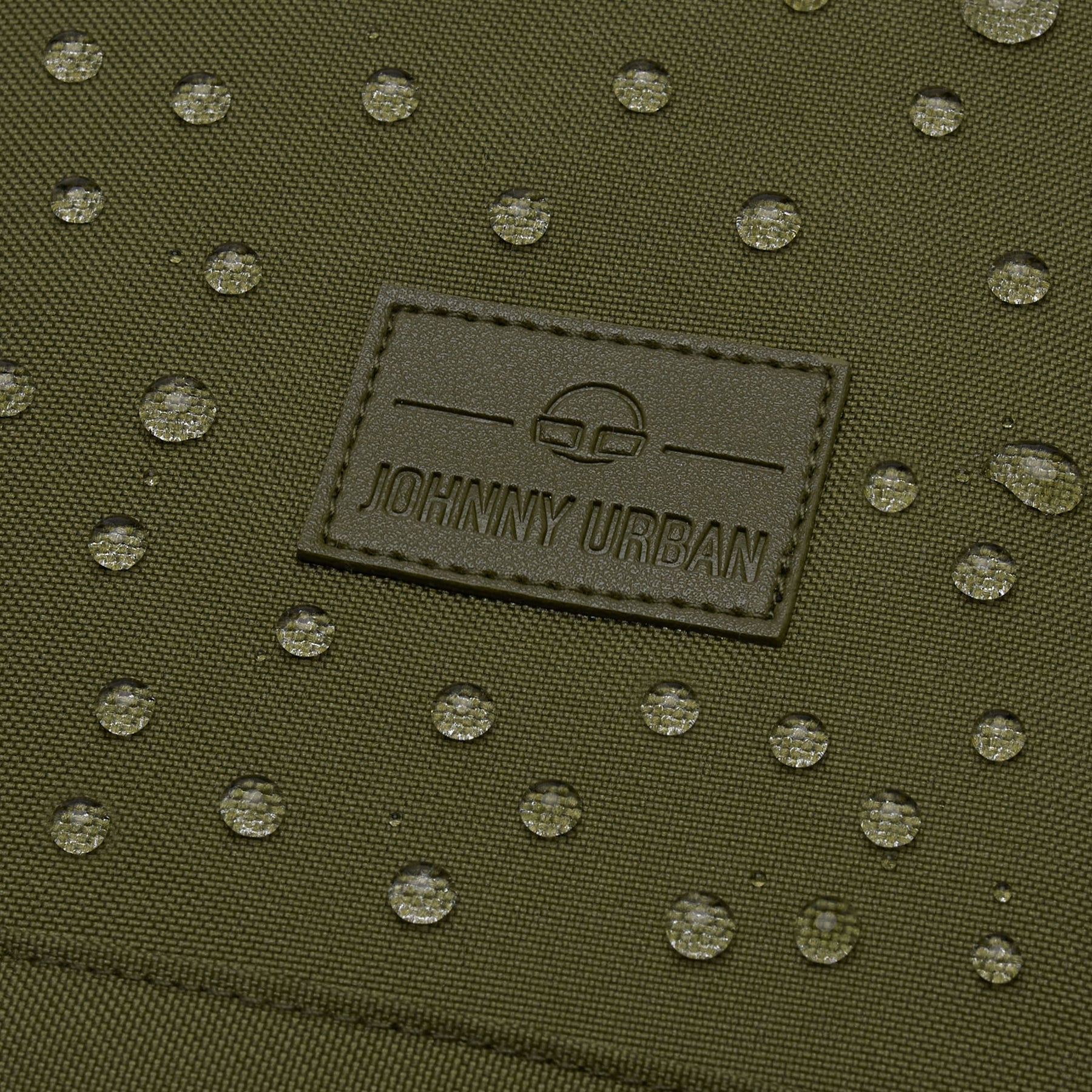 Wasserabweisendes, olivgrünes Material eines Rolltop Rucksacks mit eingesticktem 'Johnny Urban' Logo