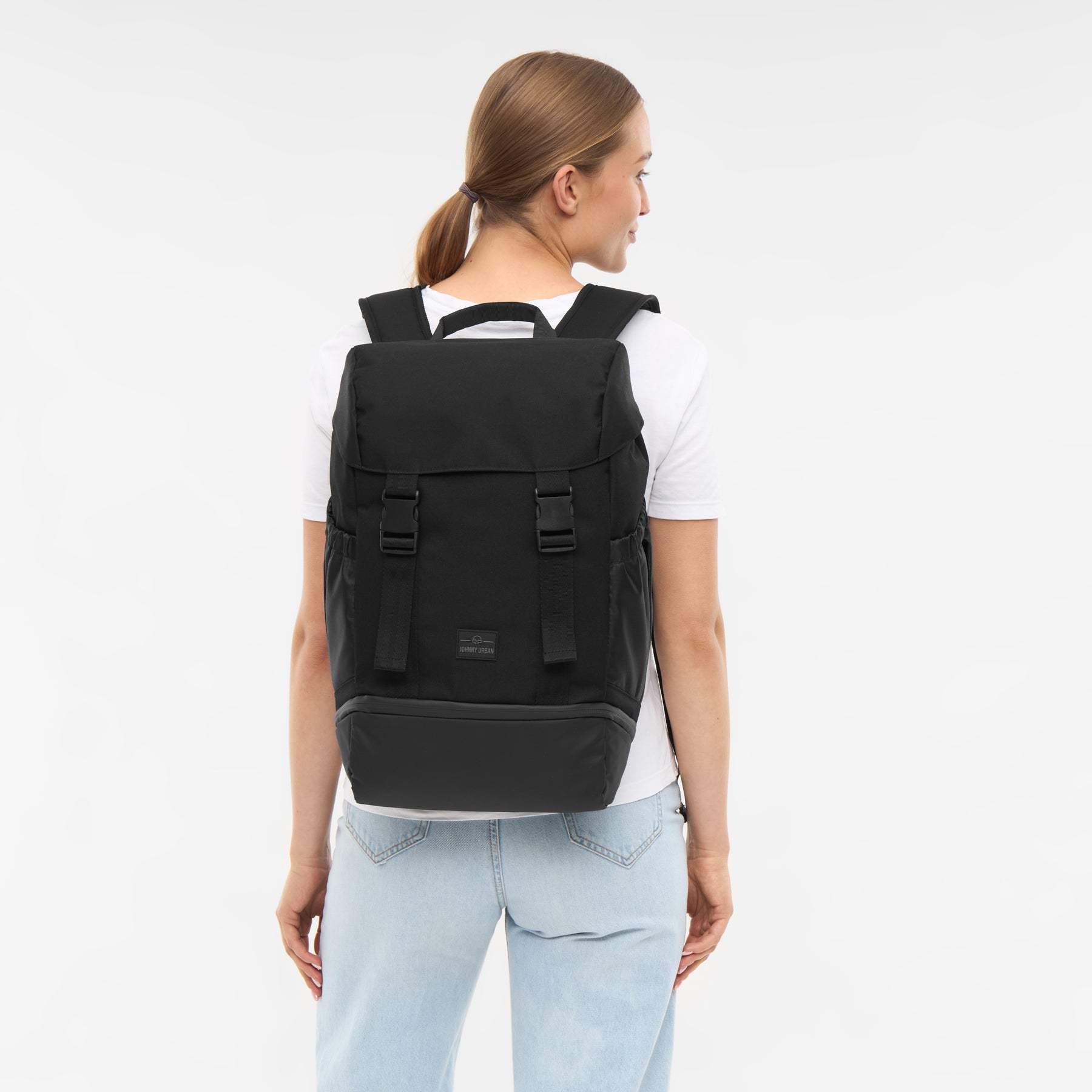 Frau trägt schwarzen Damenrucksack 'Nico' von Johnny Urban mit verschlussklappe und verstellbaren Schultergurten