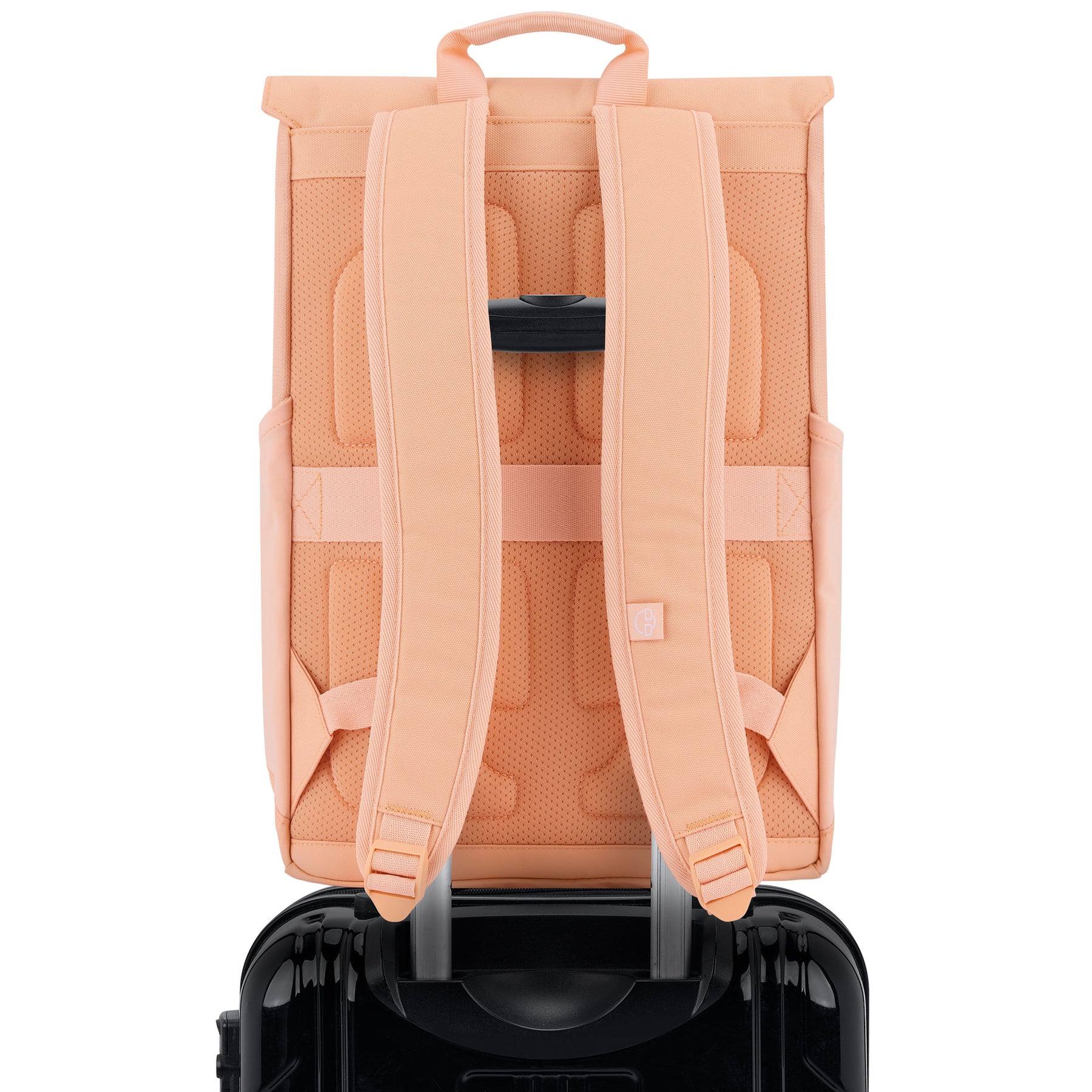 Rucksack 'Mika' in Pfirsich, Rückansicht mit gepolsterten Schulterriemen, befestigt an ausziehbarem Griff eines schwarzen Trolleys