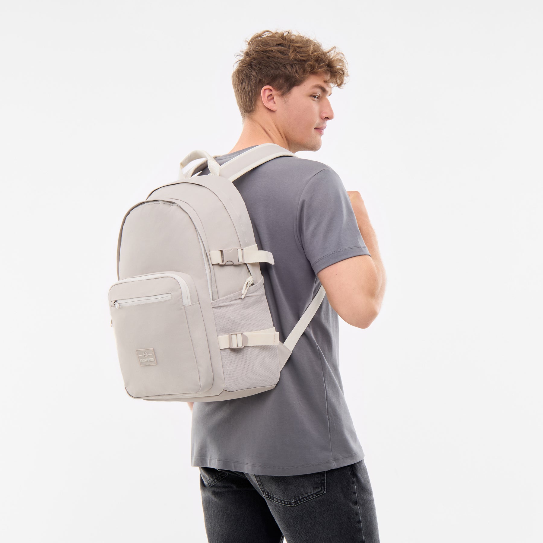 Sandfarbener Rucksack 'Lian' mit mehreren Fächern und verstellbaren Riemen auf Rücken eines Mannes mit grauem T-Shirt