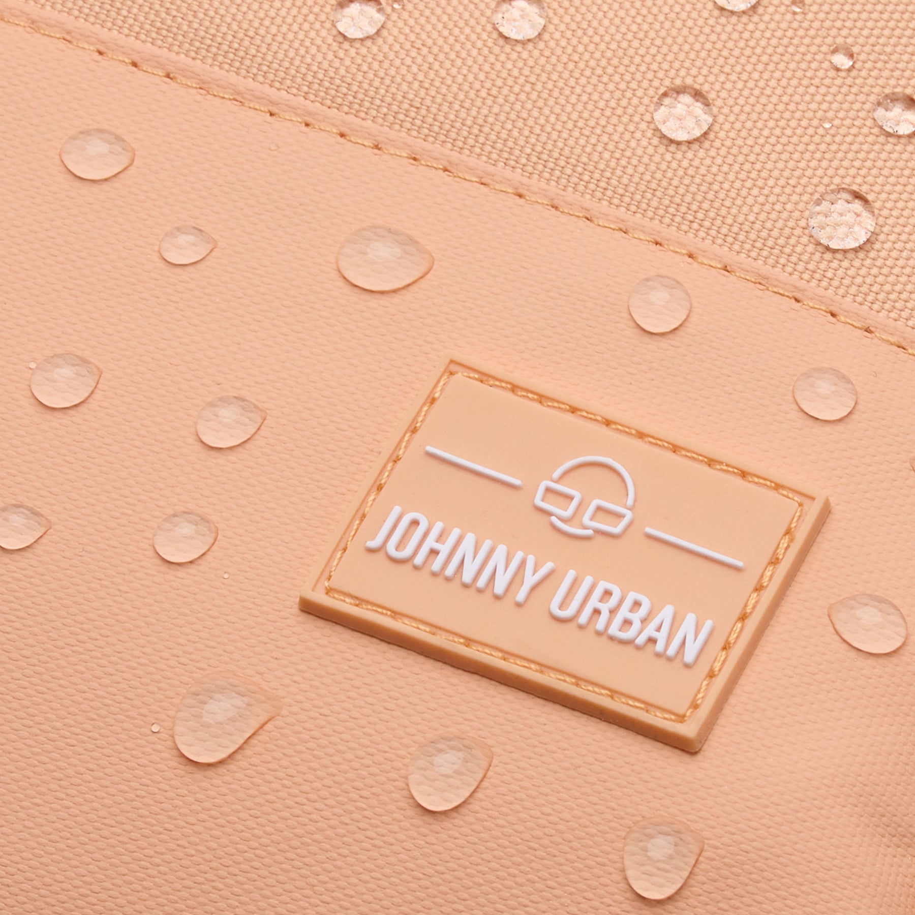 Nahaufnahme des wasserabweisenden Stoffes des Johnny Urban Rucksacks 'Mika' in Pfirsich mit Wassertröpfchen