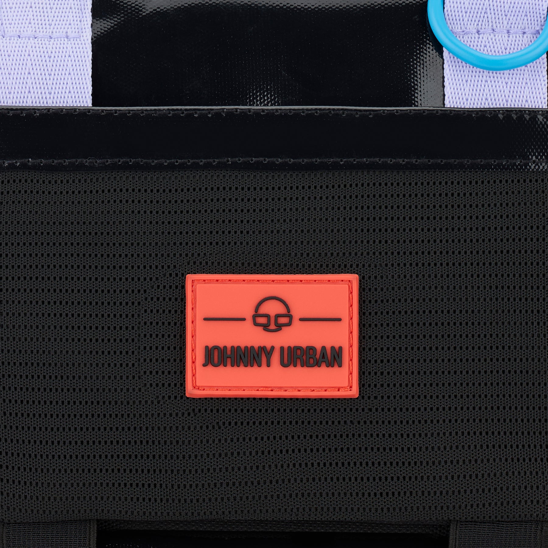 Nahaufnahme rotes Johnny Urban Logo auf schwarzem, wasserabweisendem Stoff der Umhängetasche Avery