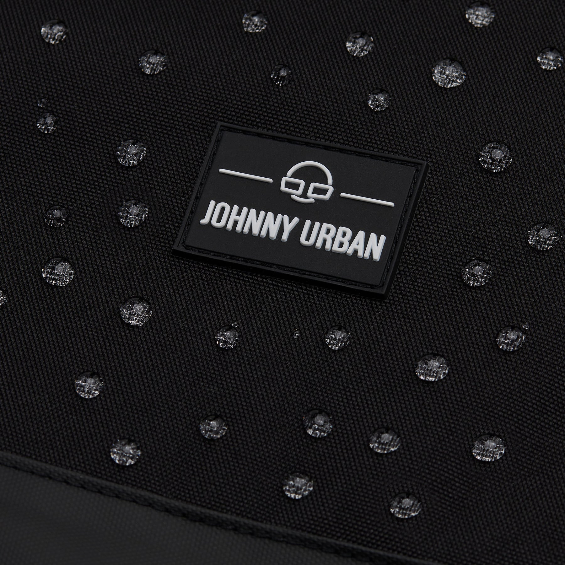Nahaufnahme des wasserabweisenden schwarzen Rucksacks 'Neo' von Johnny Urban mit Wasserperlen auf dem Material