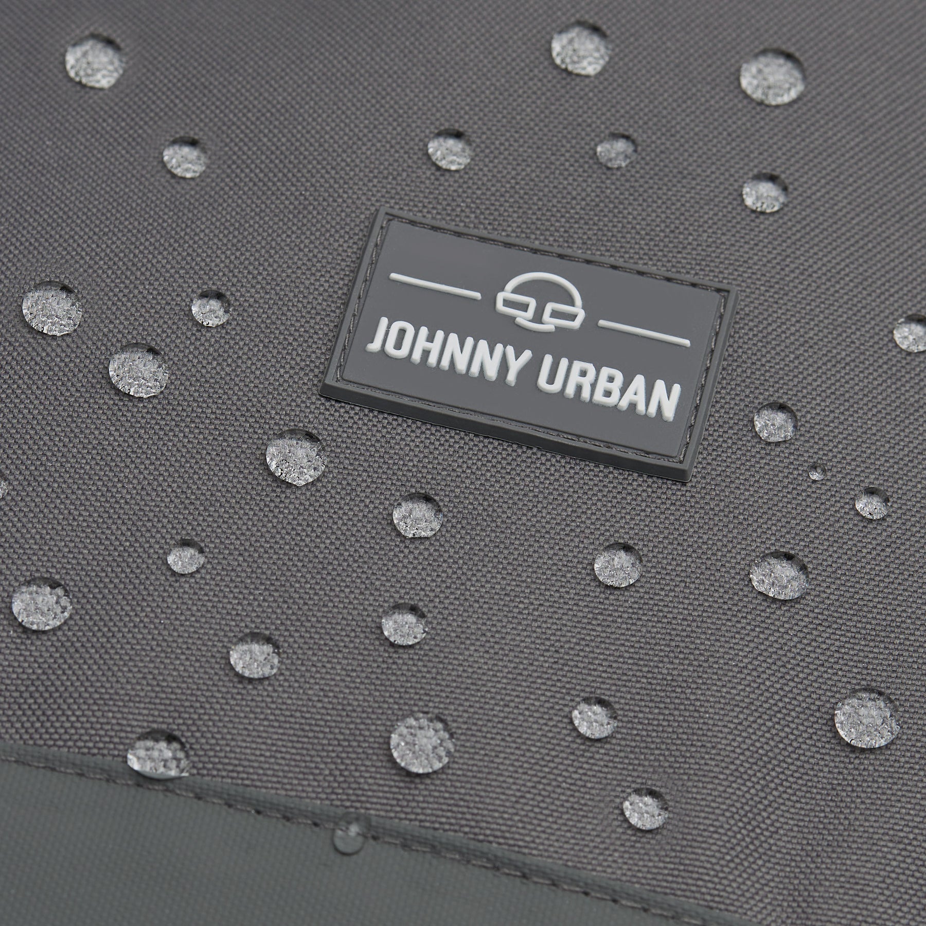 Wasserabweisendes graues Material mit Johnny Urban Logo und Wasserperlen