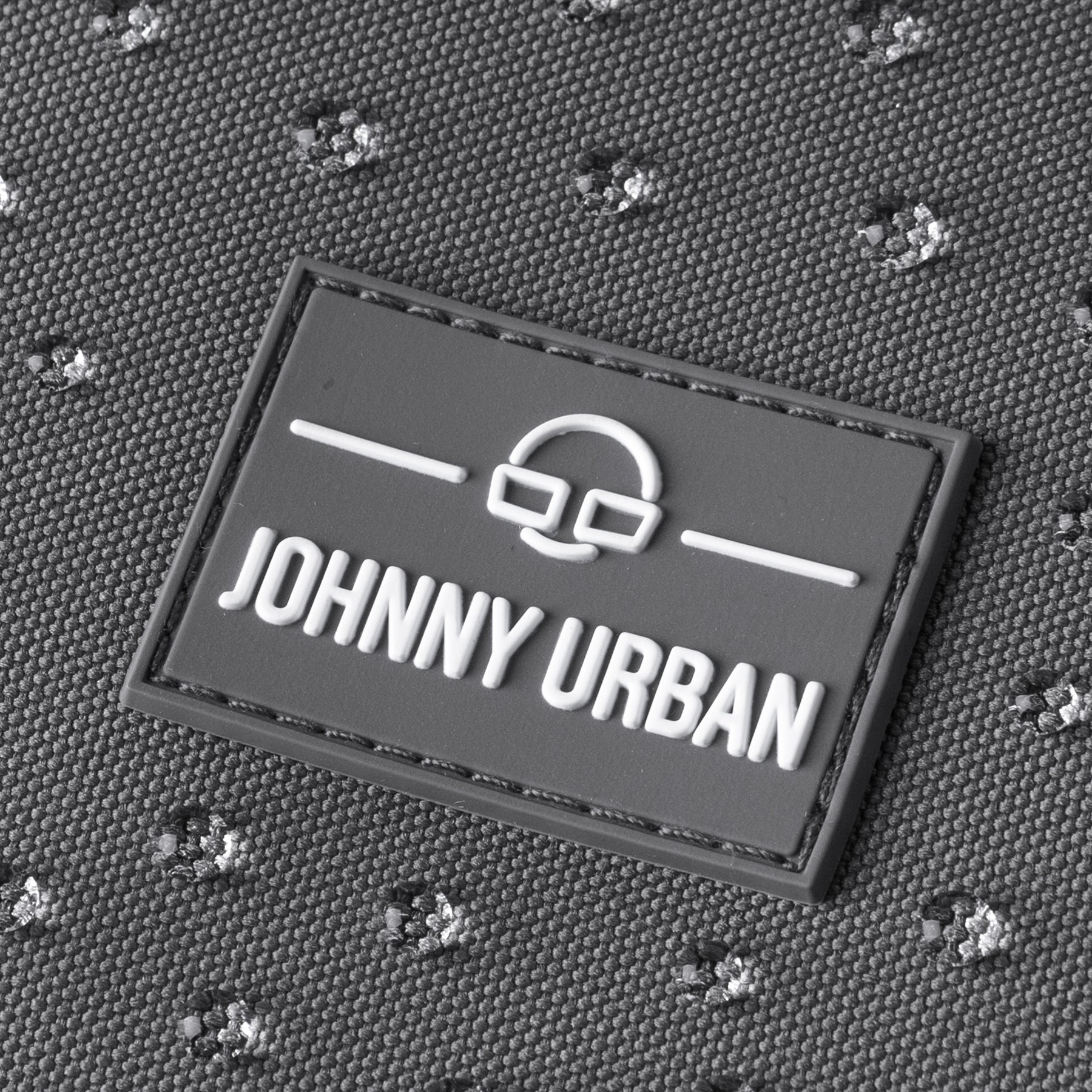Johnny Urban Logo auf dunkelgrauem, wasserfestem Rucksackstoff mit Struktur