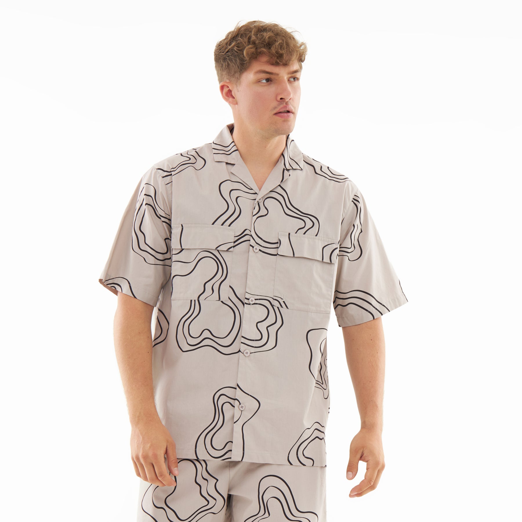 Mann trägt sandfarbenes Hemd mit abstraktem schwarzem Linienmuster, Teil des Sets 'Spencer'