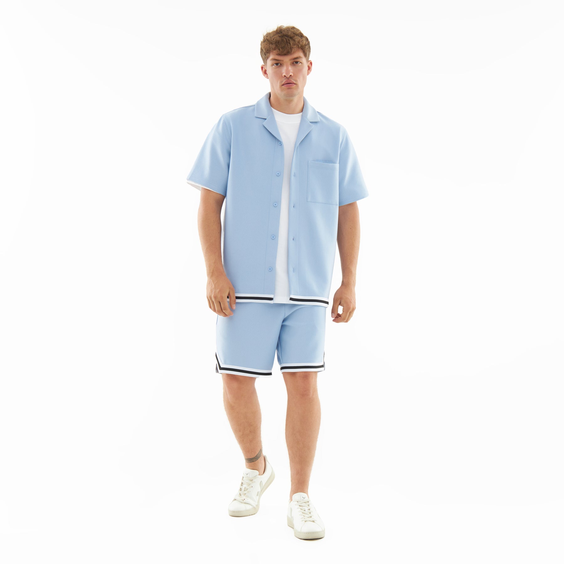 Mann in hellblauem Sommerhemd und Shorts mit schwarzen und weißen Streifen, Teil des Sets 'Parker'