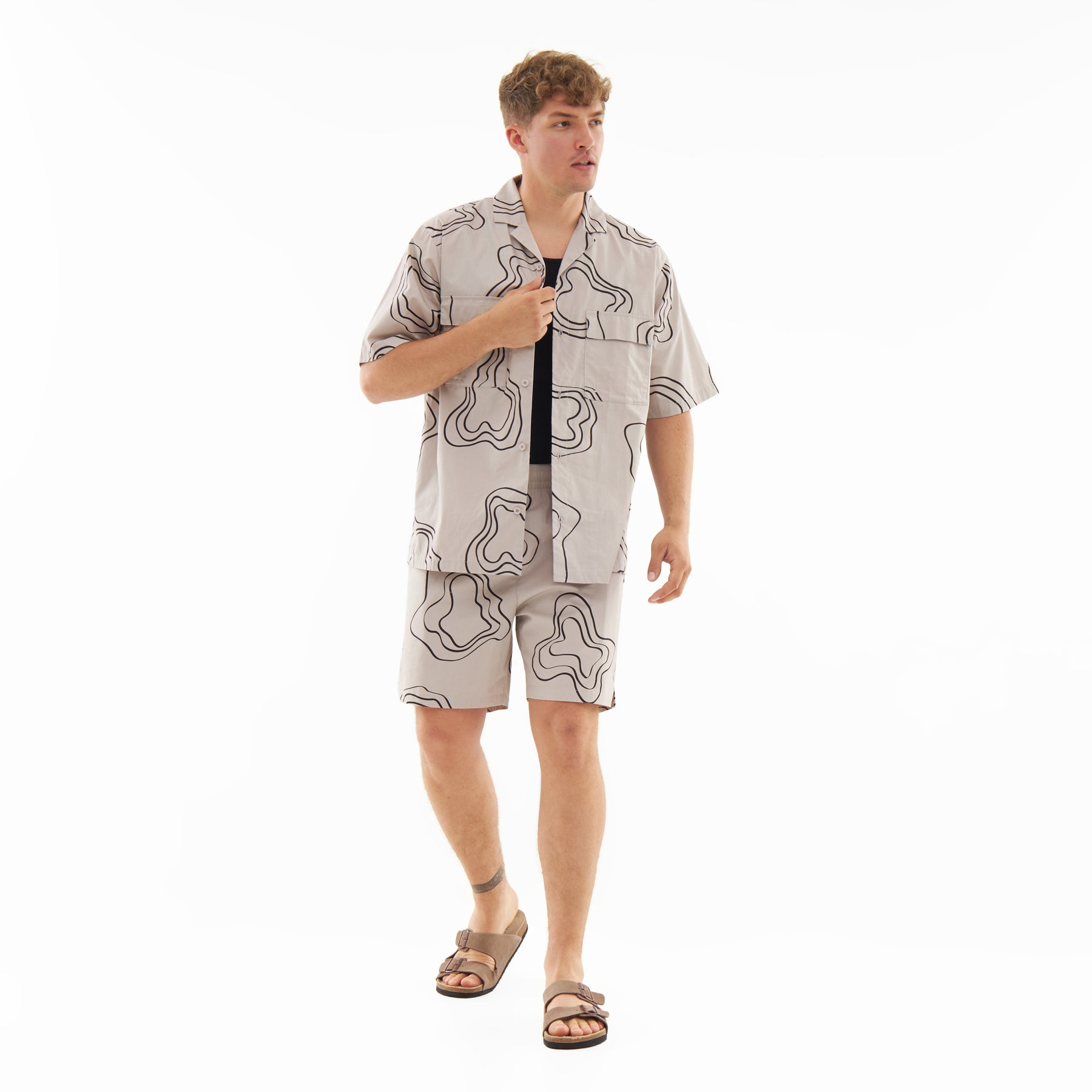 Mann trägt gemusterte sandfarbene Shorts Spencer und passende kurzärmelige Hemdjacke, braune Sandalen