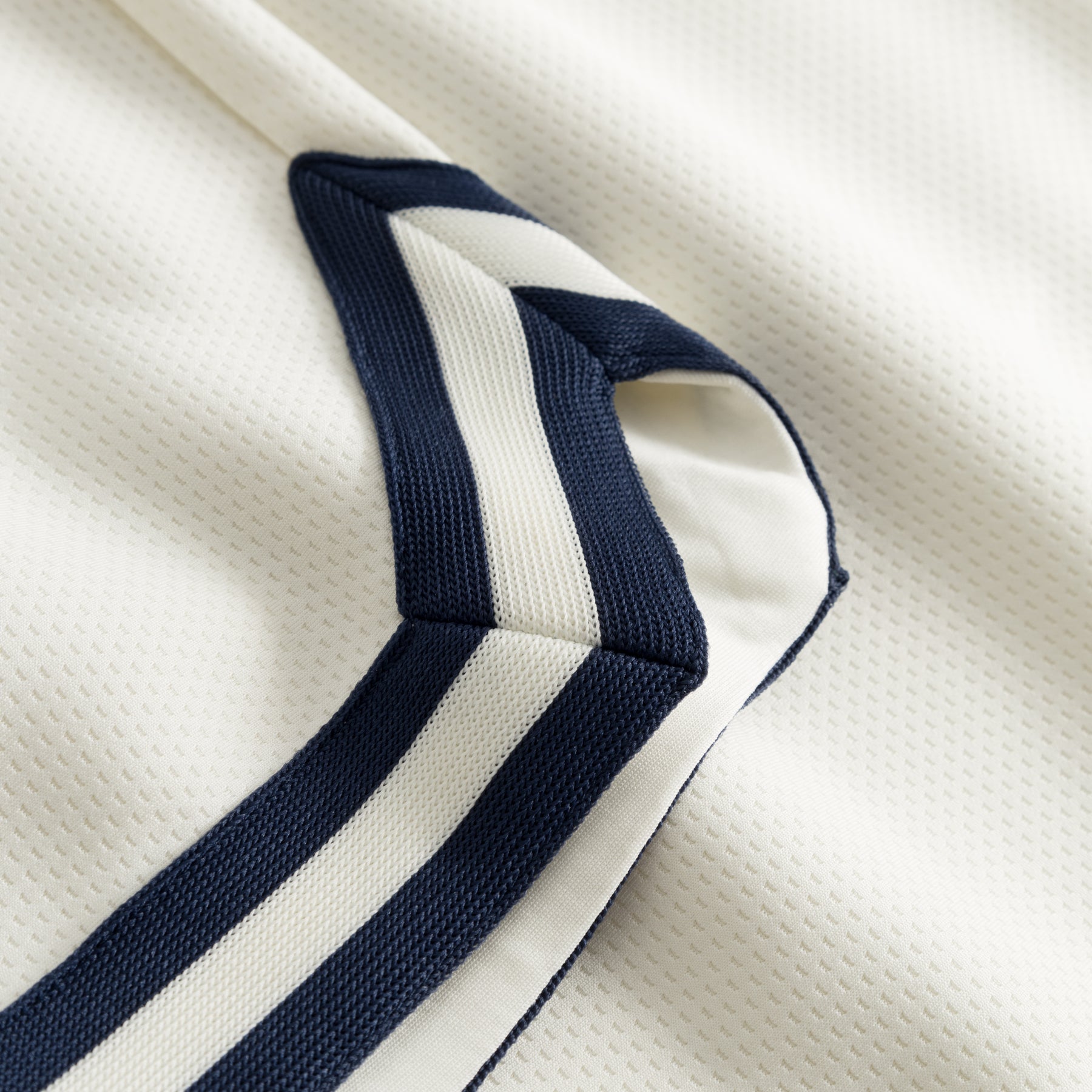 Nahaufnahme einer cremefarbenen Shorts aus dem Set 'Parker' mit dunkelblauen und weißen Streifendetails