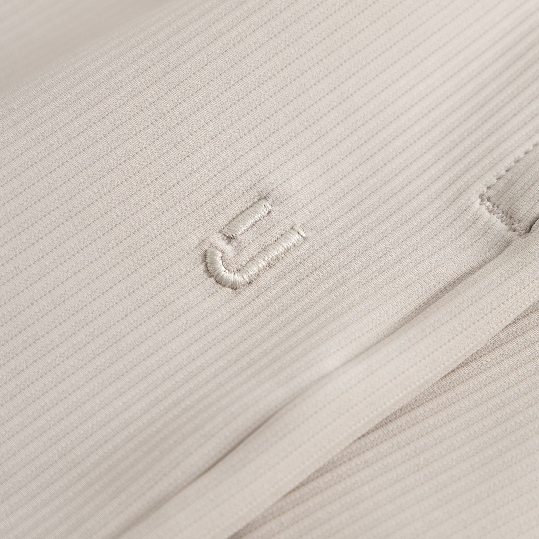 Nahe Aufnahme der sandfarbenen Stoffstruktur der Shorts 'Mason' mit feiner Rippung und gesticktem Detail