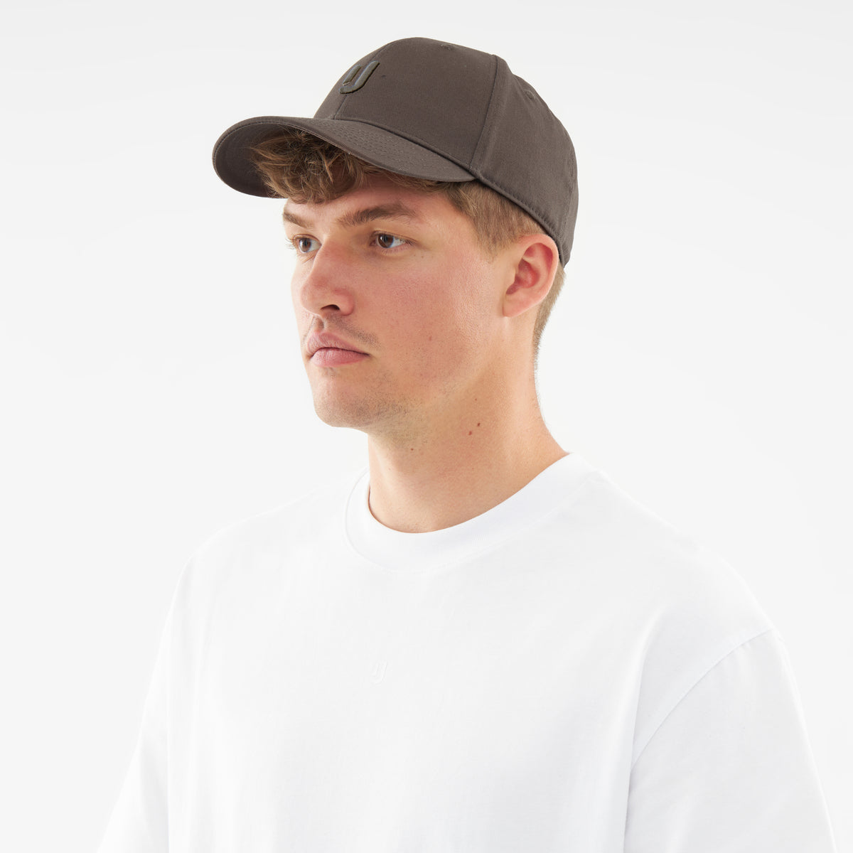 Mann trägt graue Johnny Urban Snapback-Cap 'Jason' und weißes T-Shirt, Blick nach links