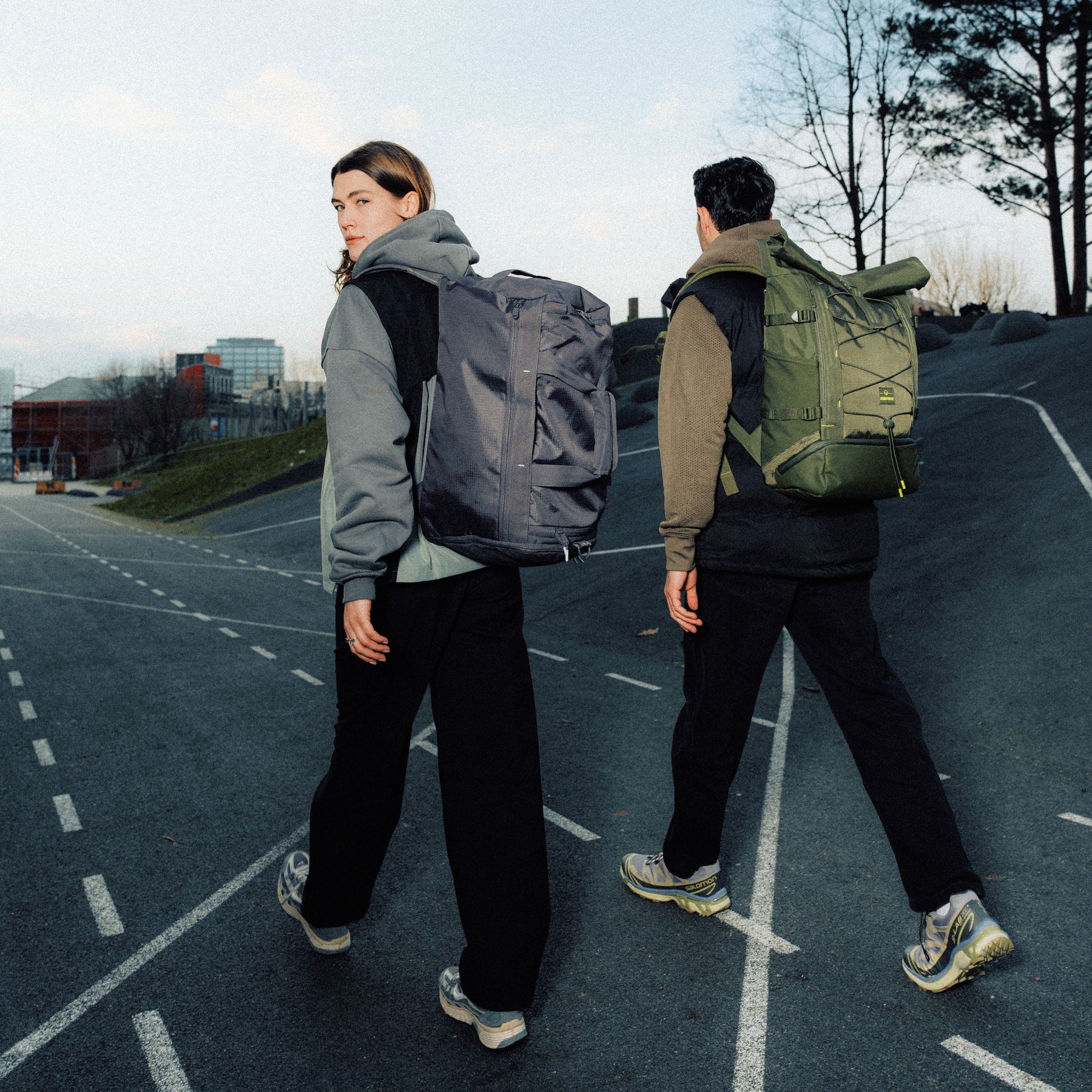 Zwei Personen gehen auf einer Straße, eine trägt eine graue Duffle Bag 'Shawn Medium' von Johnny Urban auf dem Rücken