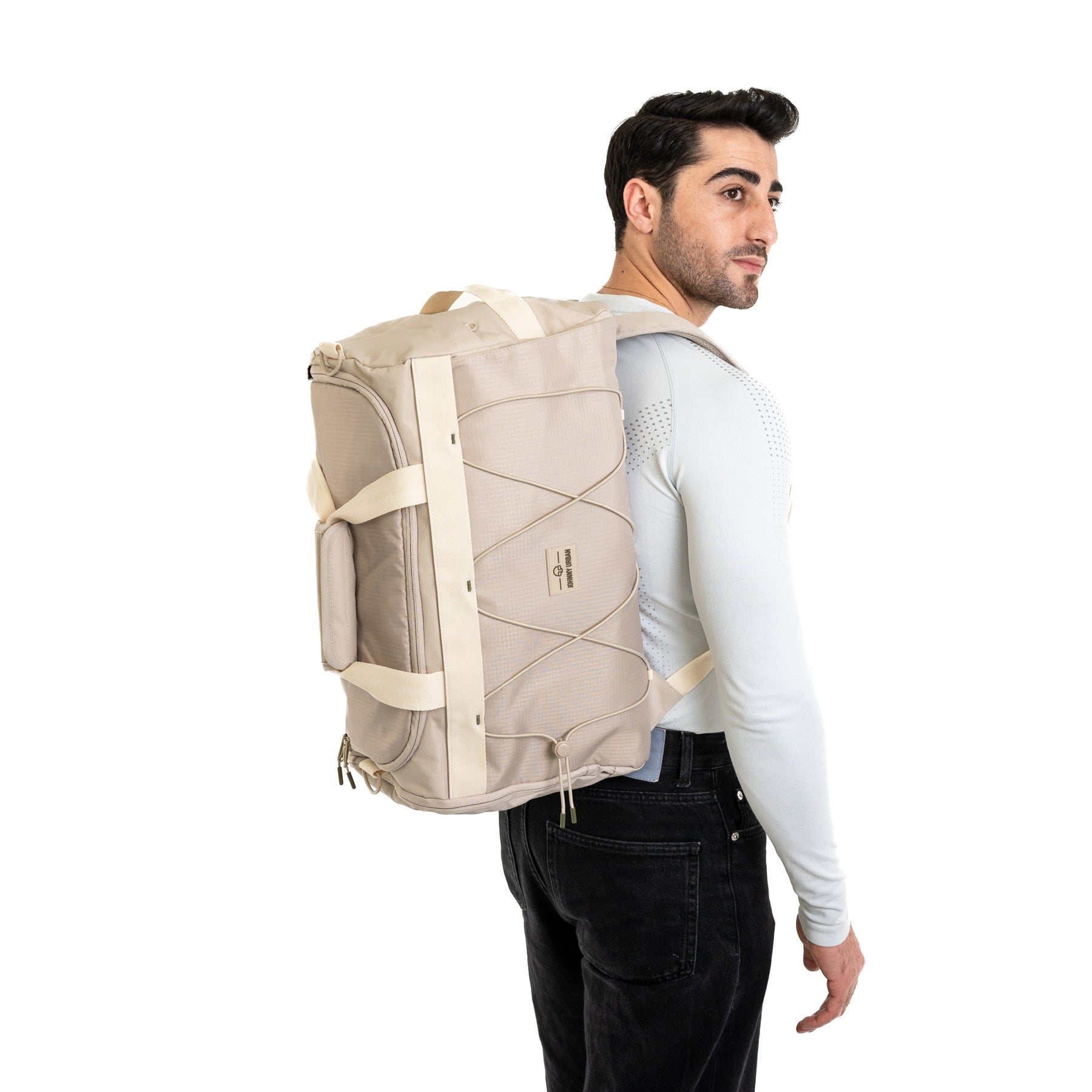 Beiger Duffle Bag 'Shawn Medium' von Johnny Urban, getragen von Mann mit weißem langärmligem Shirt und schwarzer Hose