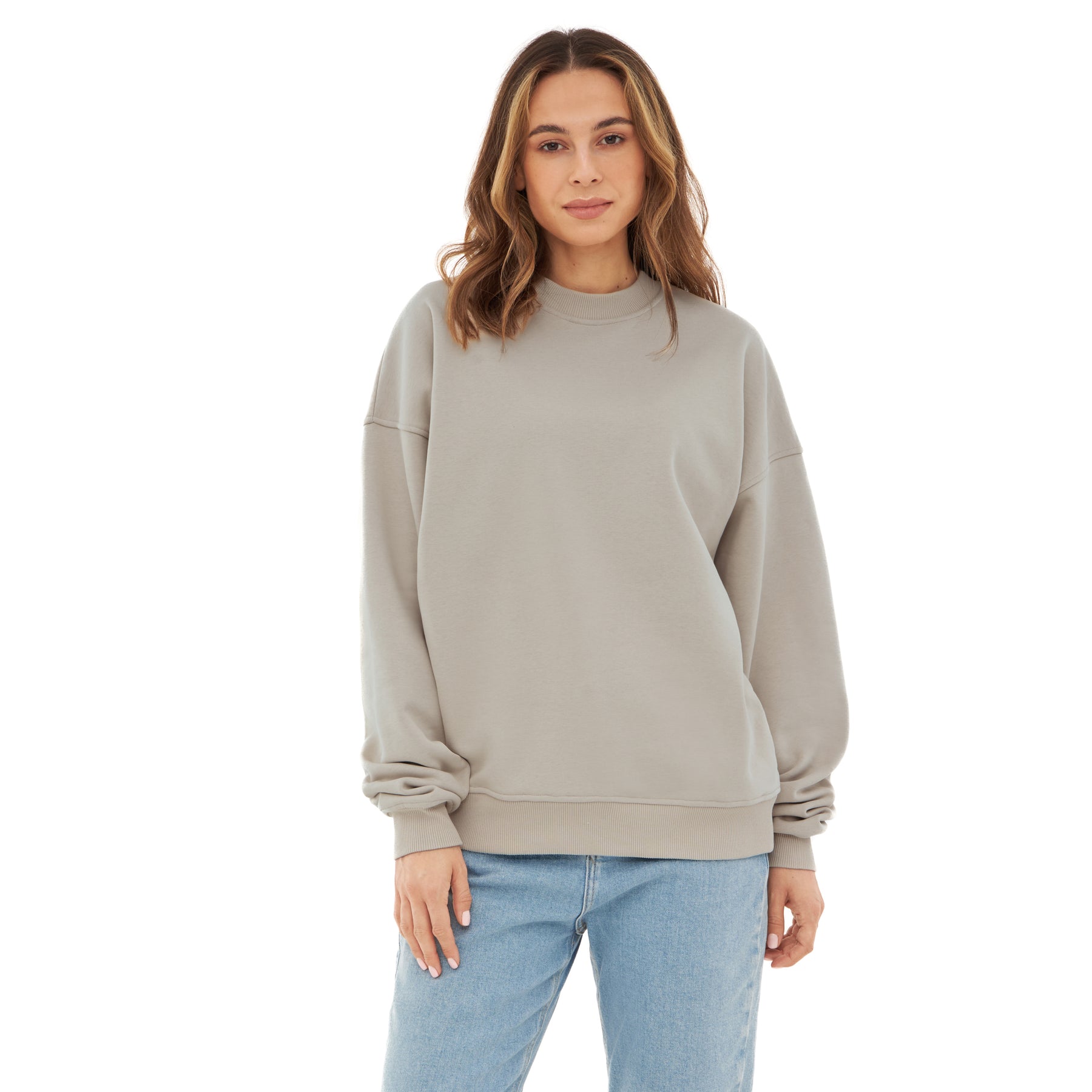Frau trägt oversized beige Crewneck-Pullover ‚Carter‘ von Johnny Urban mit blauer Jeans