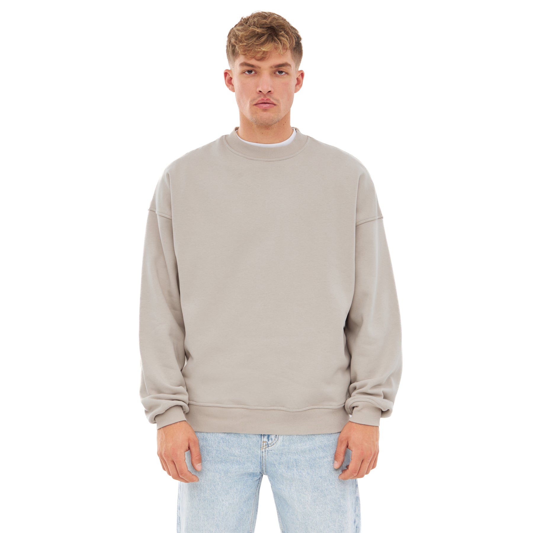 Beiger, übergroßer Herren-Crewneck-Pullover 'Carter' von Johnny Urban, getragen mit hellblauen Jeans
