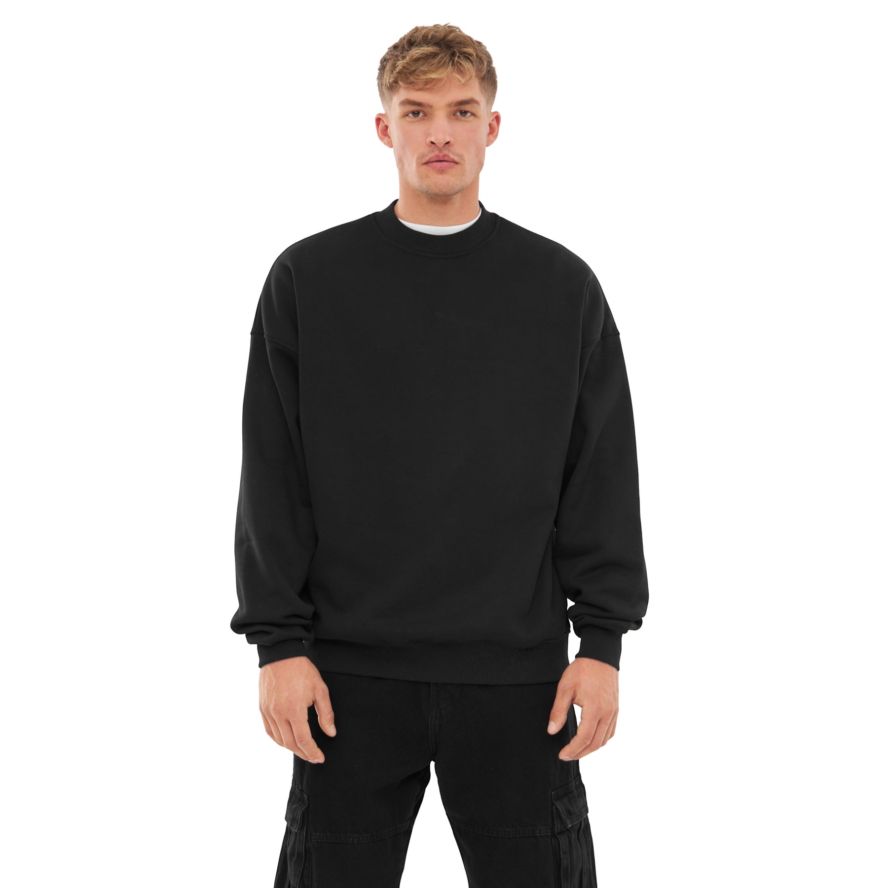 Mann trägt schwarzen oversized Crewneck Pullover 'Carter' und schwarze Cargo-Hose
